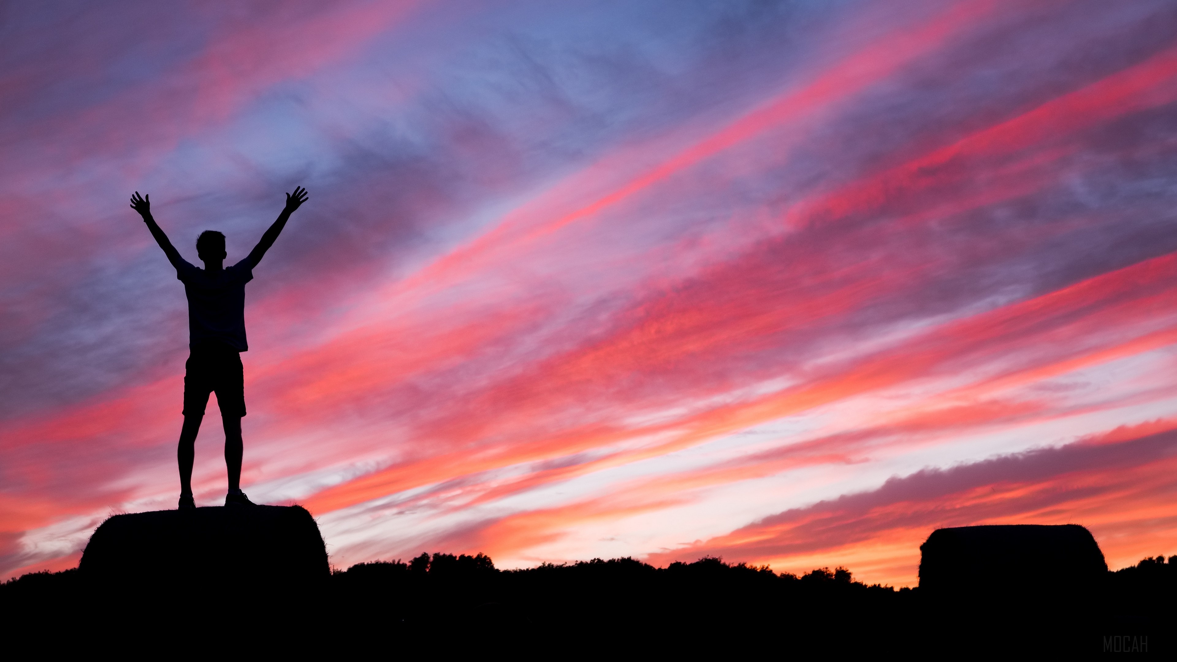 Man silhouetted against a colorful sunset sky HD Wallpaper