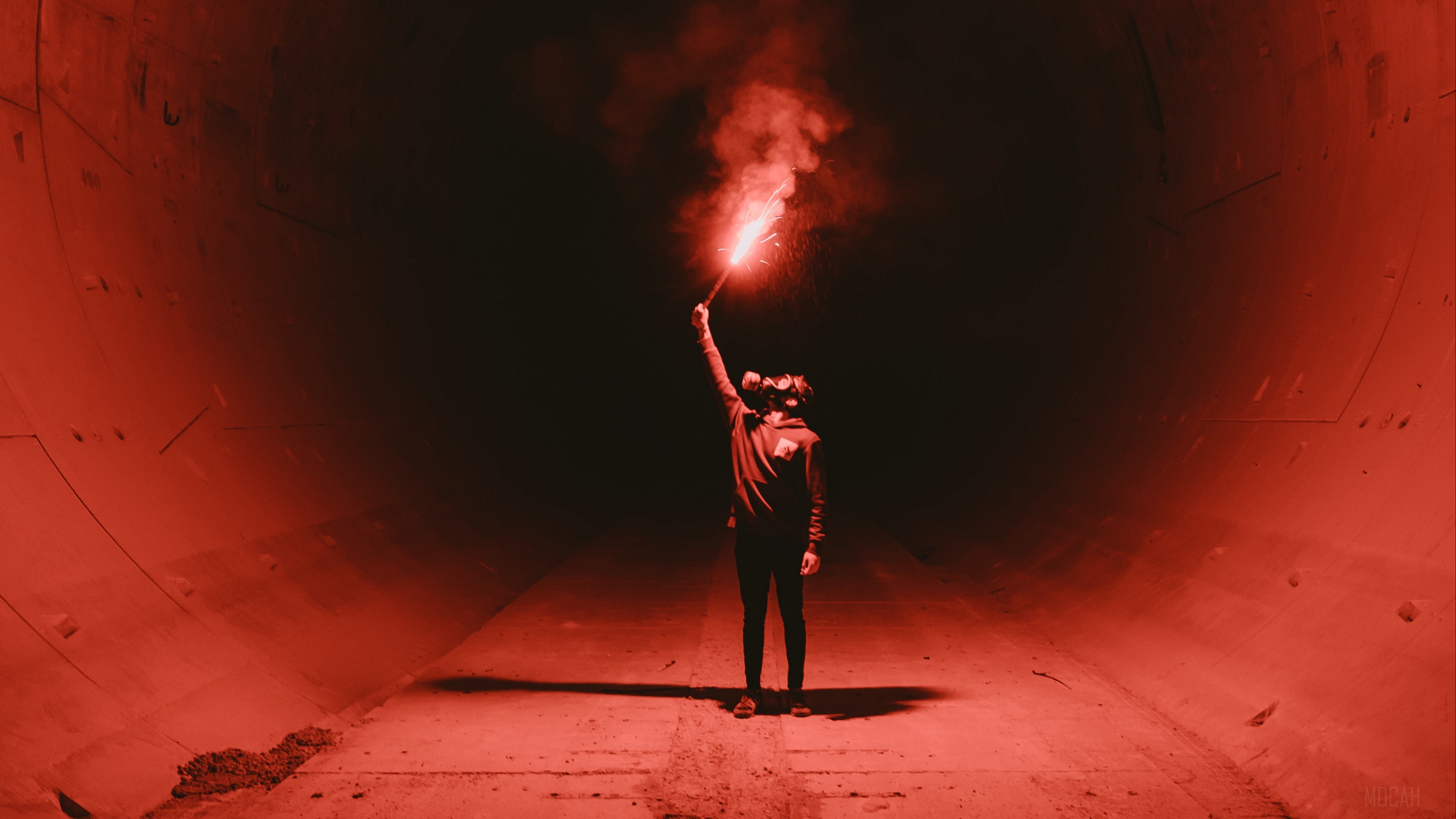 Man in gas mask holding red flare in tunnel 4K HD Wallpaper