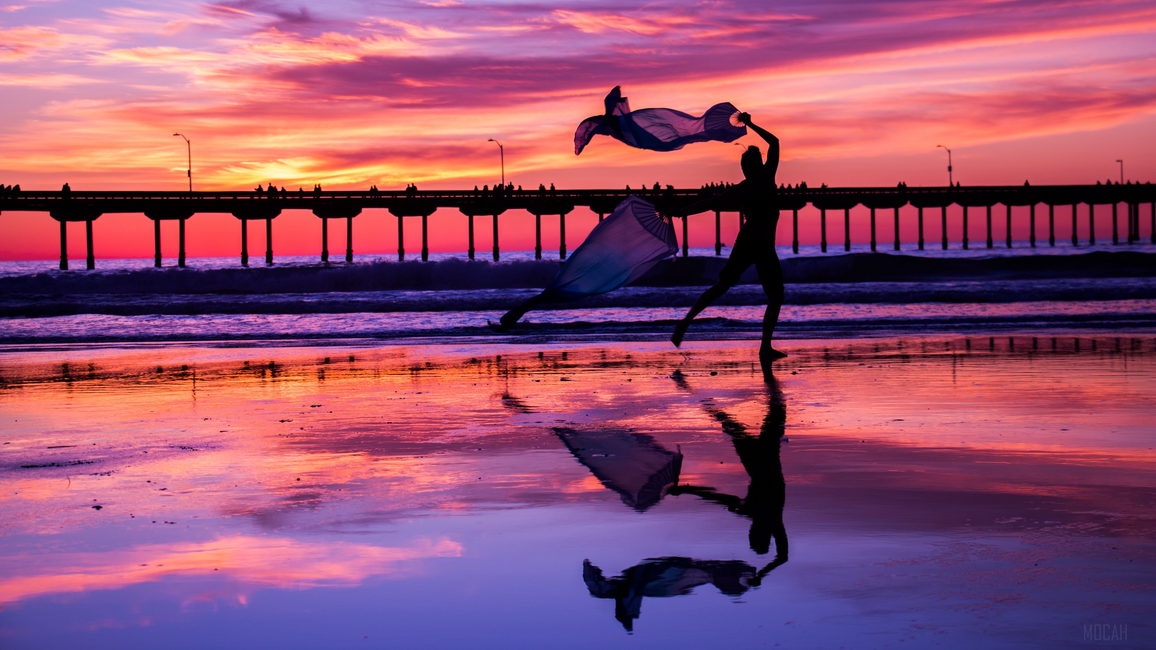 Silhouette dancer with flowing fabric on beach at sunset near pier HD Wallpaper