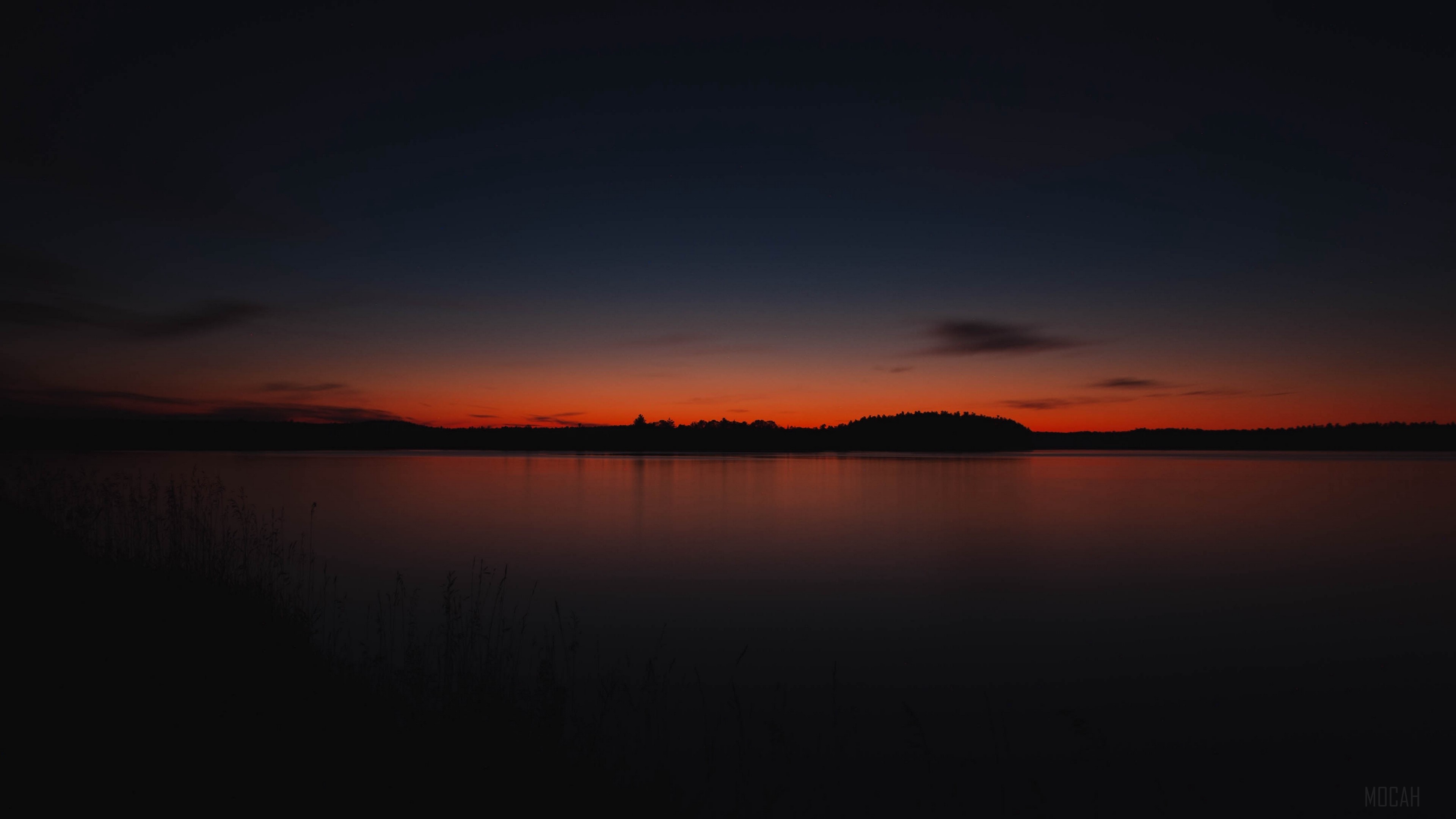 Sunset over a lake with trees on the horizon HD Wallpaper