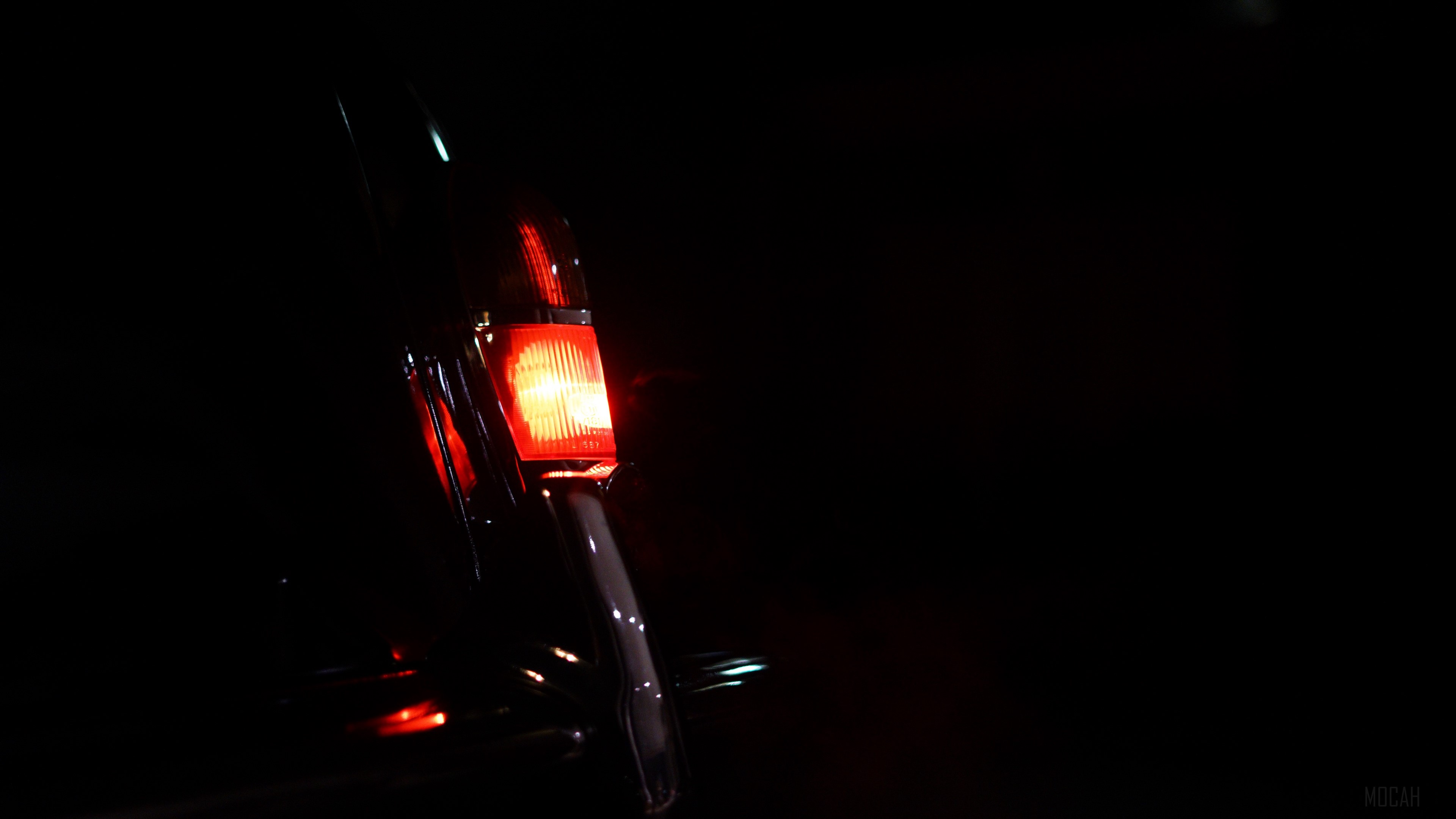 Close-up of a car's red taillight at night HD Wallpaper