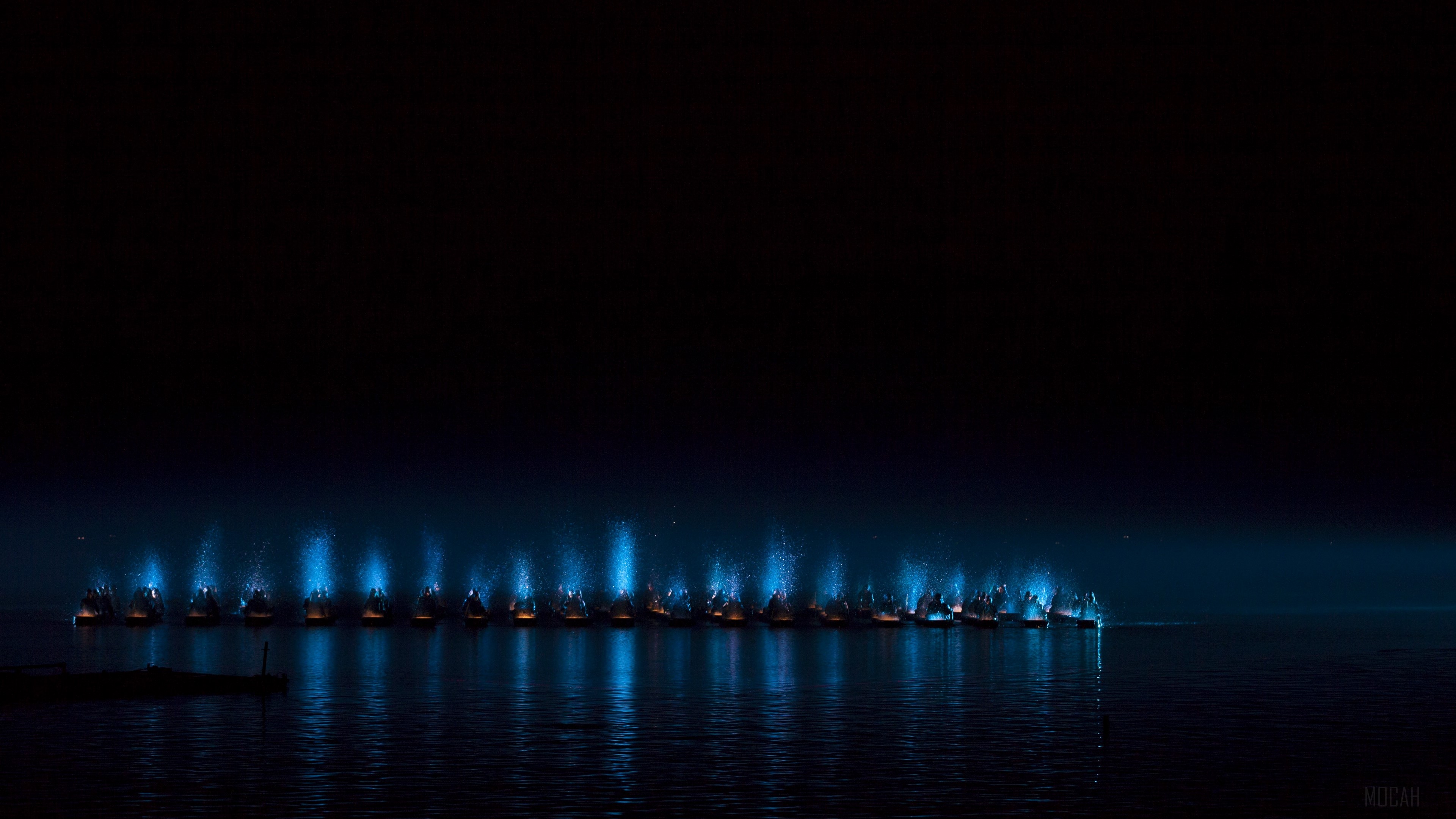 Boats with blue lights on the sea at night HD Wallpaper