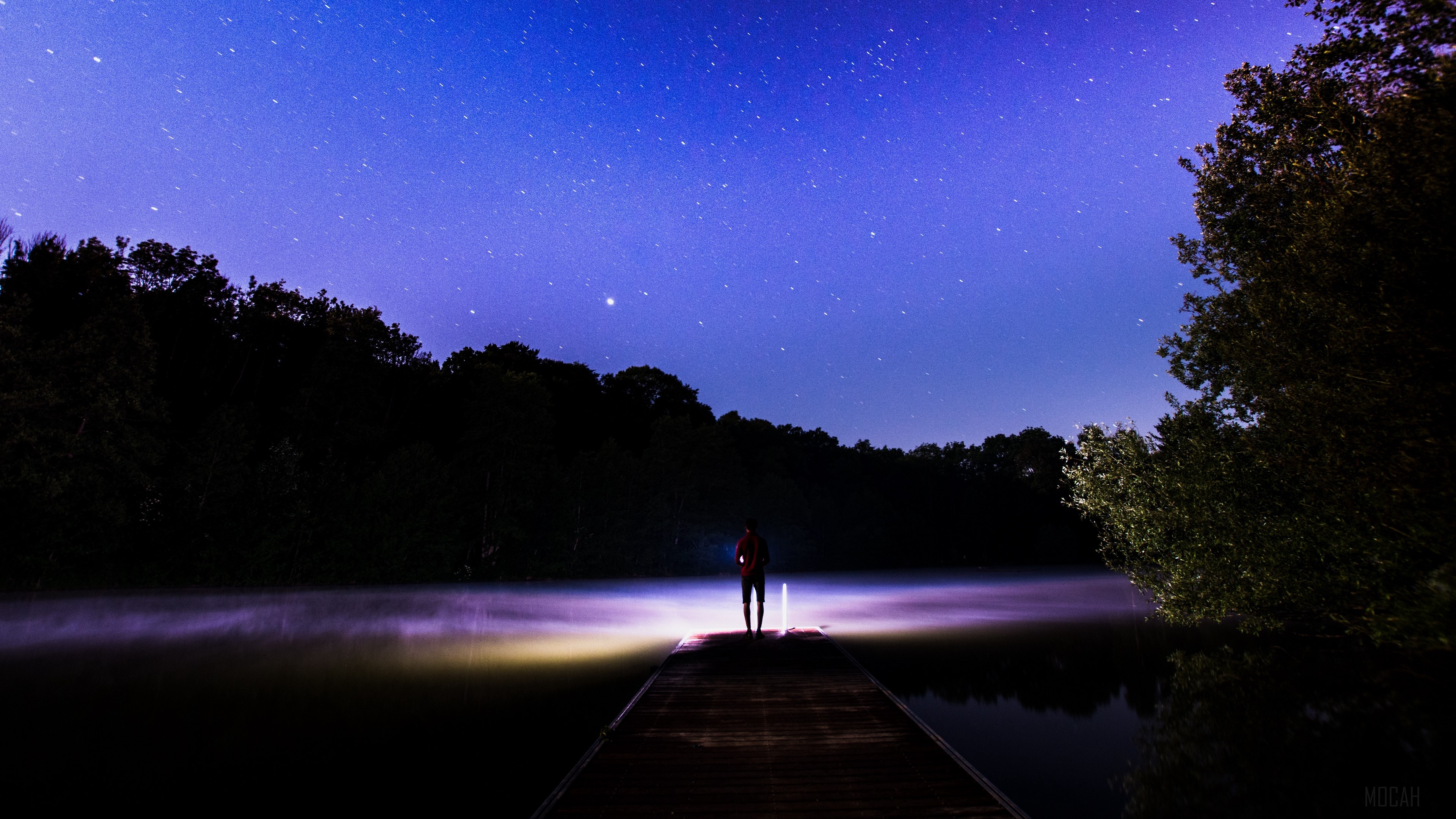 Person on dock under starry sky with fog HD Wallpaper