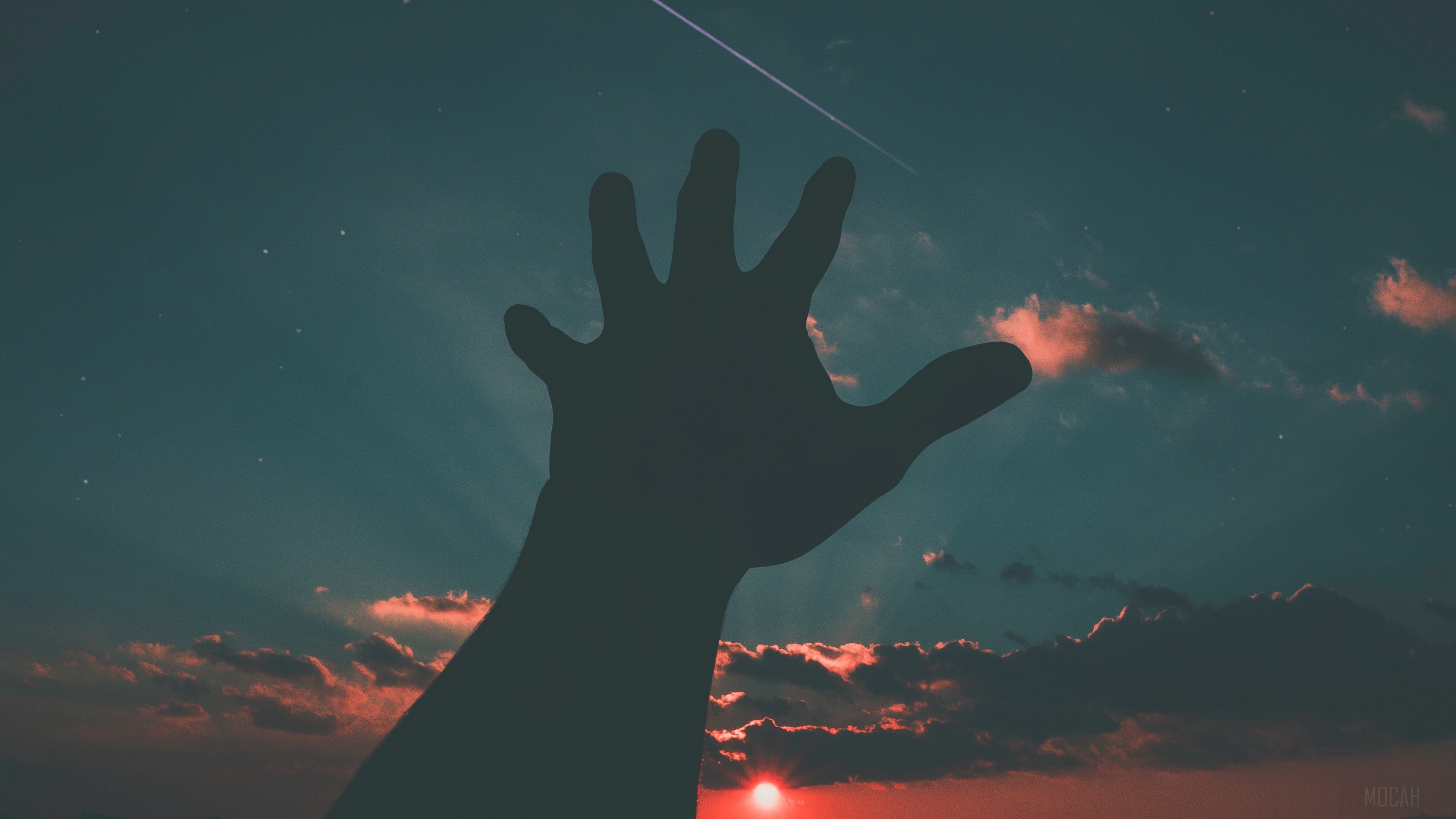 Silhouette of a hand reaching towards a starry sky with a sunset HD Wallpaper