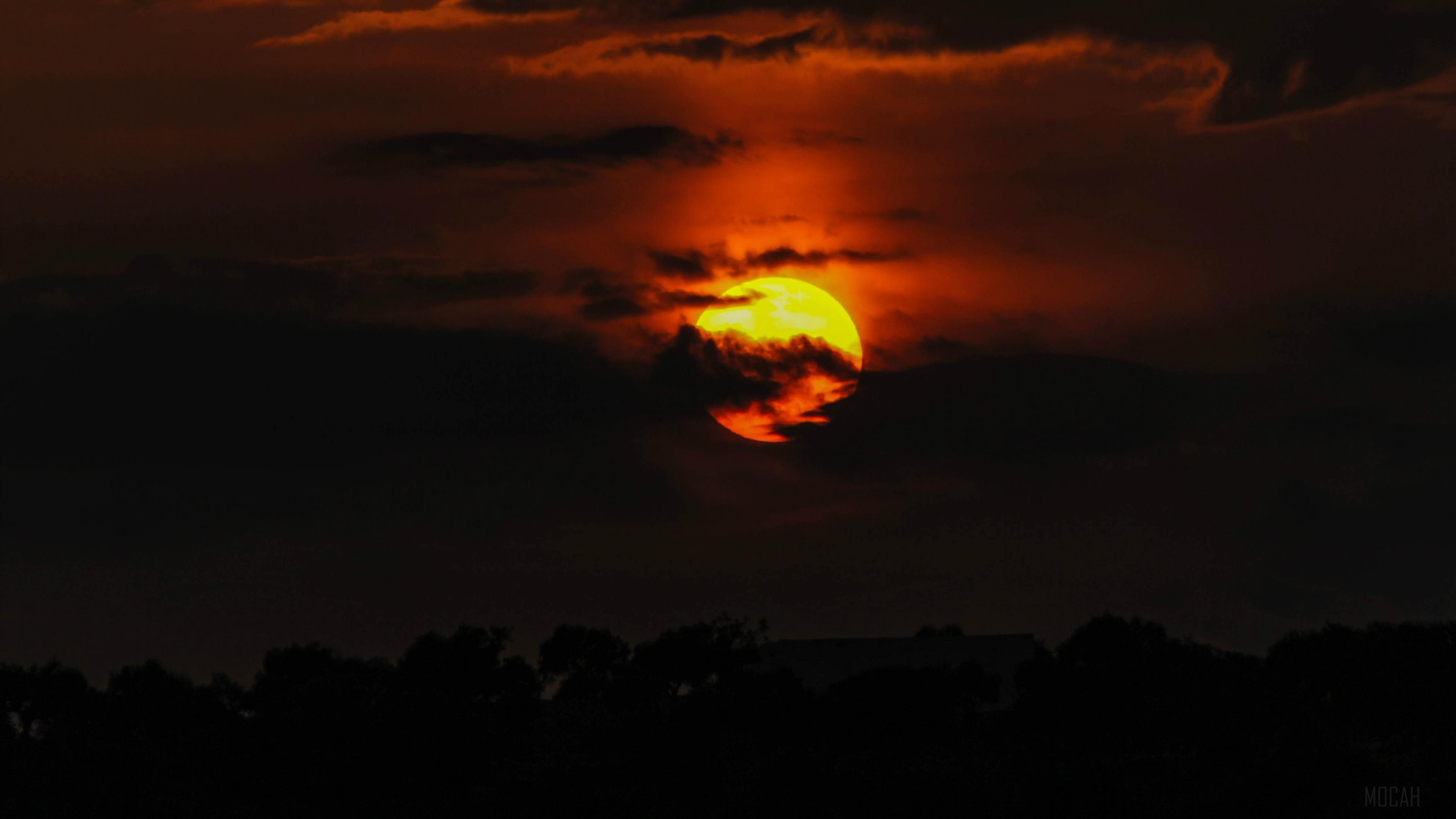 Sunset behind clouds with silhouette of trees HD Wallpaper