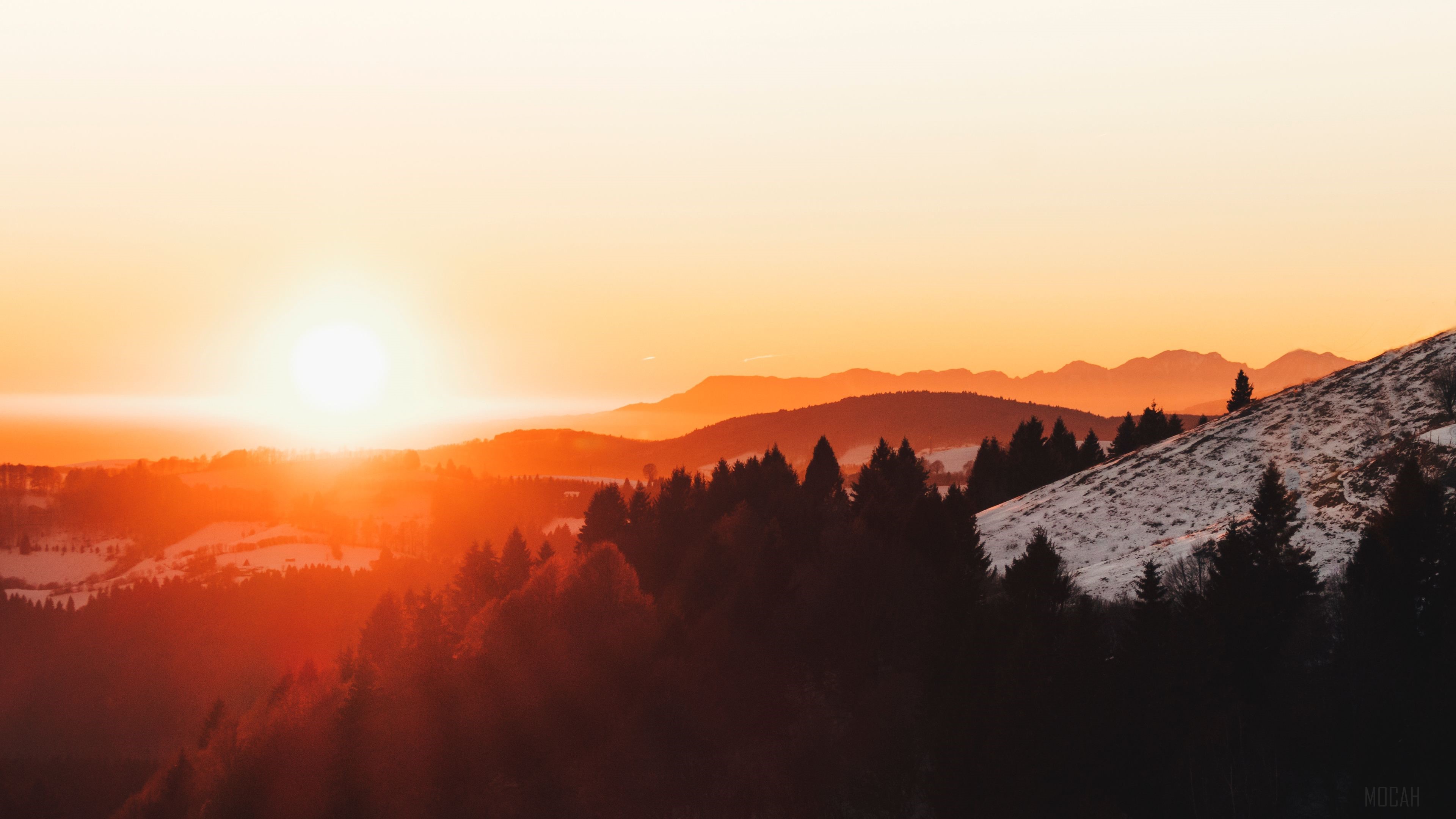 Sunset over forested mountains HD Wallpaper