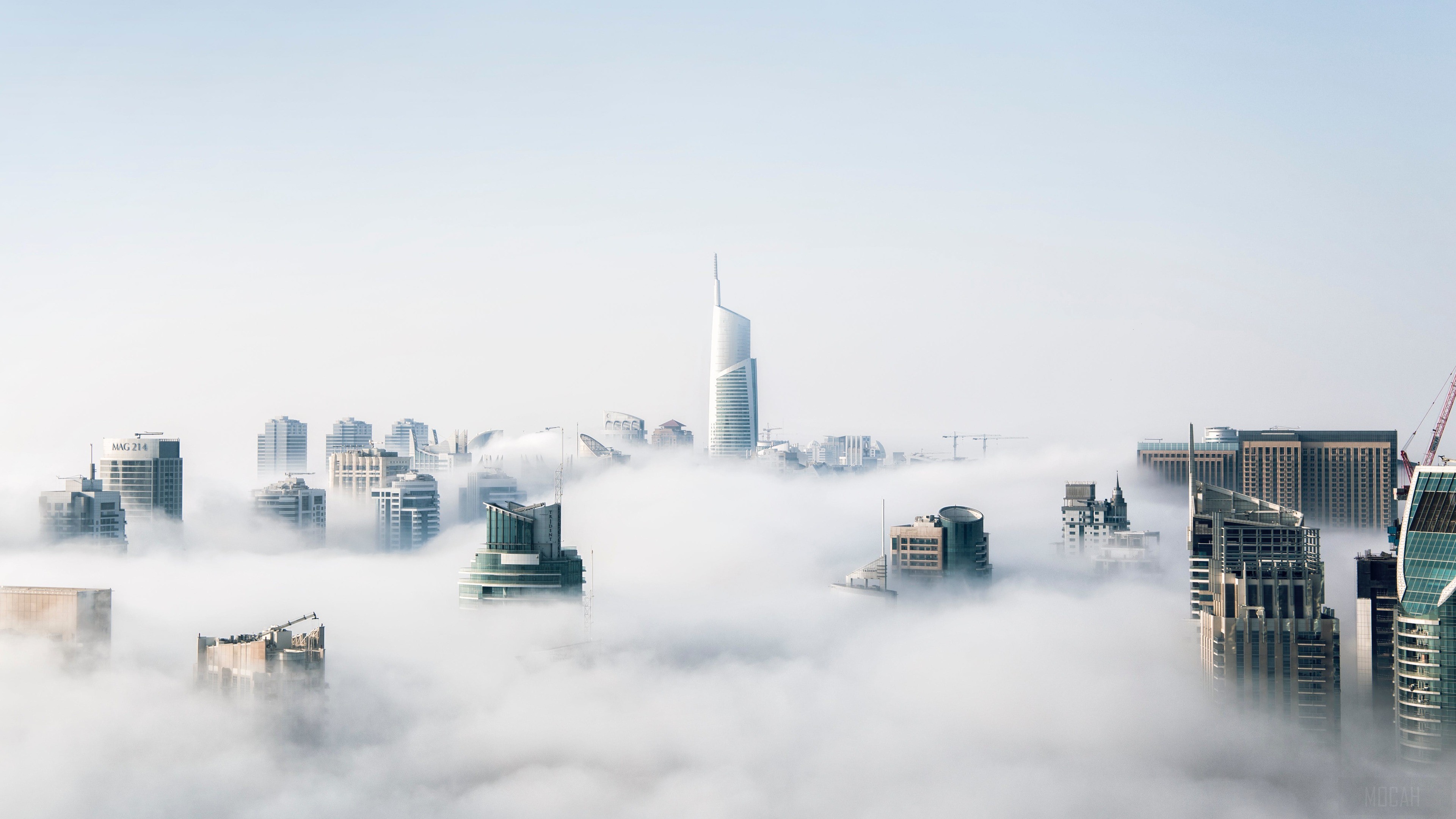 Skyscrapers emerging from fog in a city HD Wallpaper