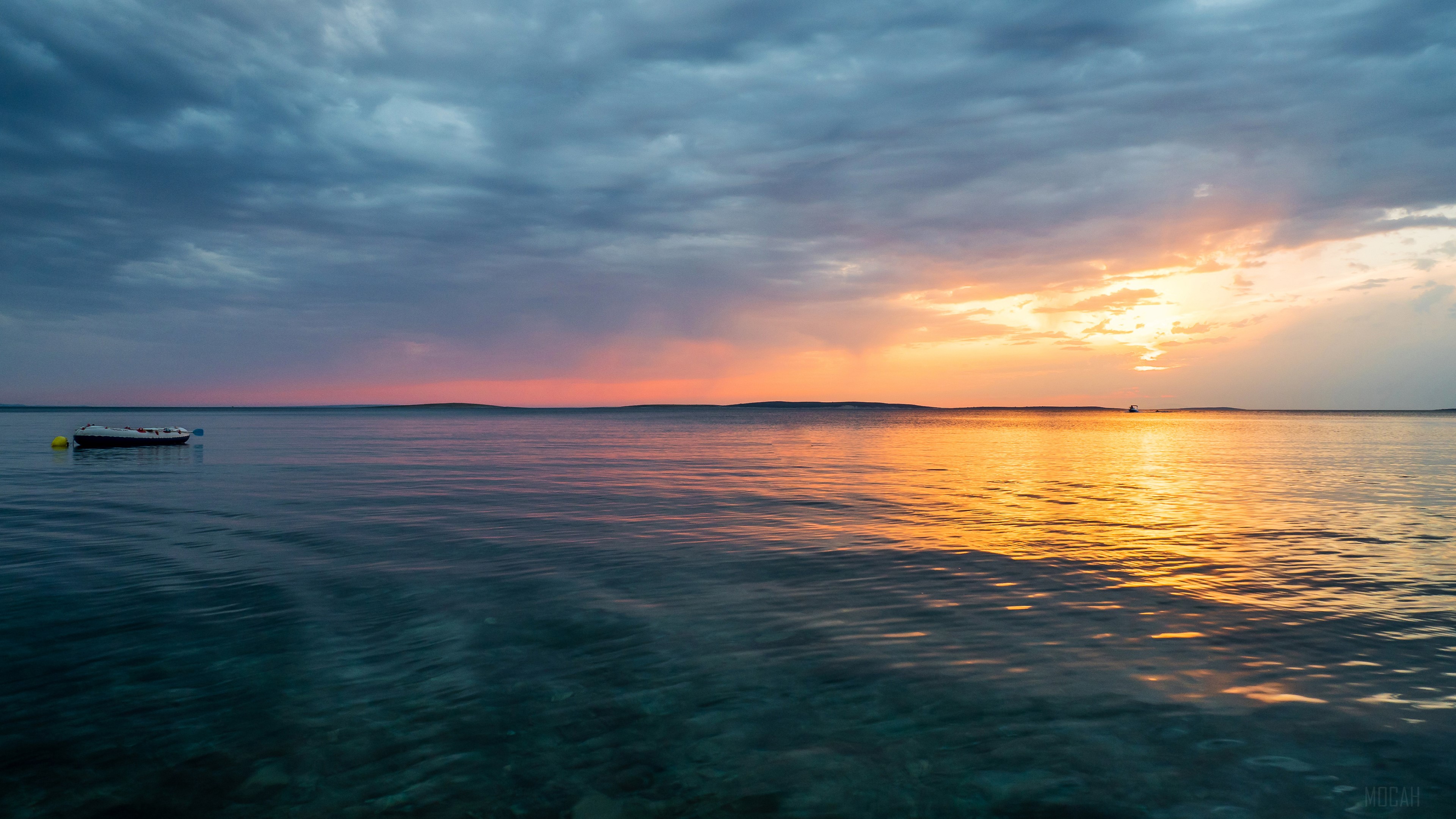 Sunset over a calm lake with a boat HD Wallpaper
