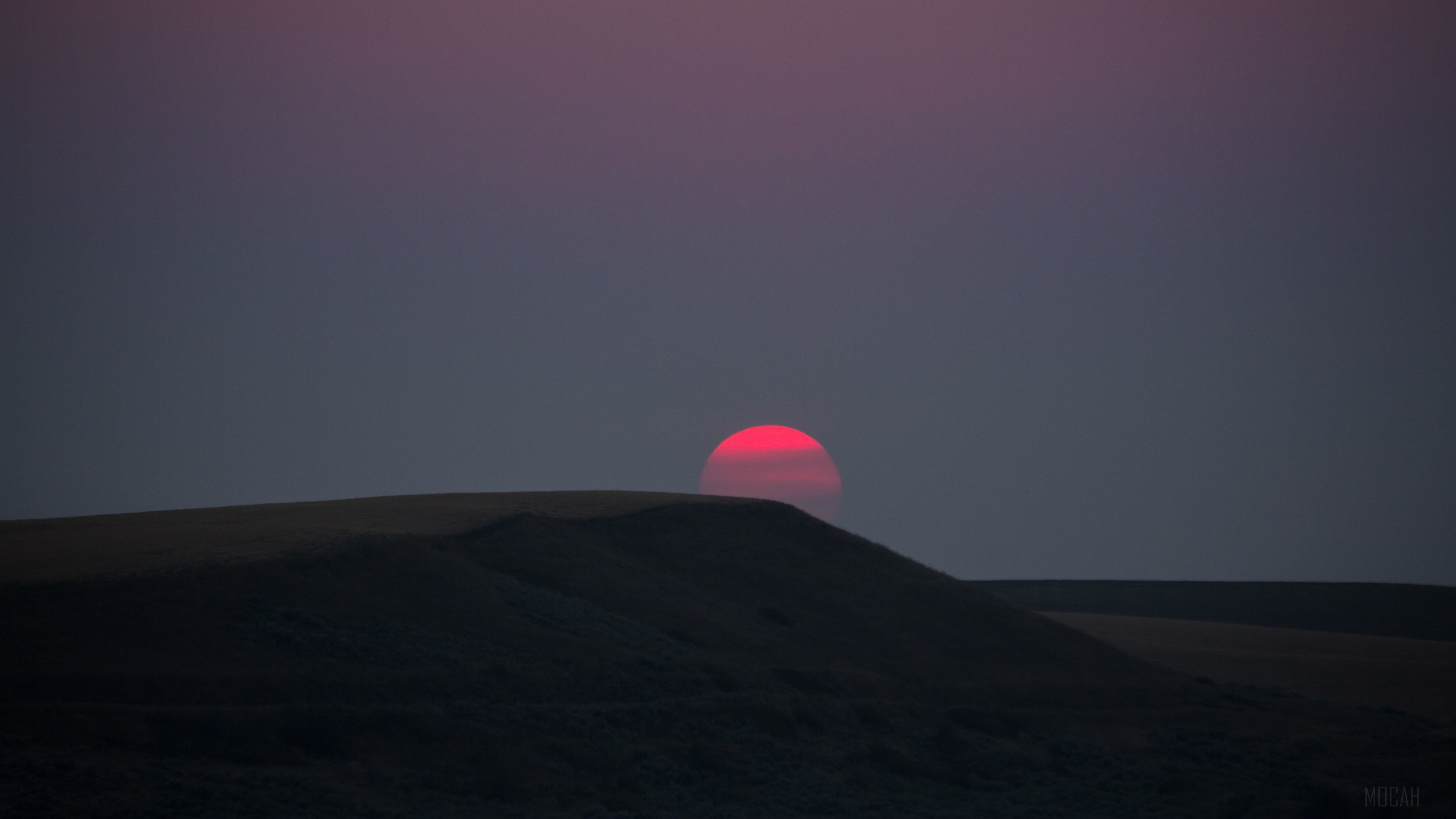 Red Sun Setting Over Dark Landscape 4K HD Wallpaper