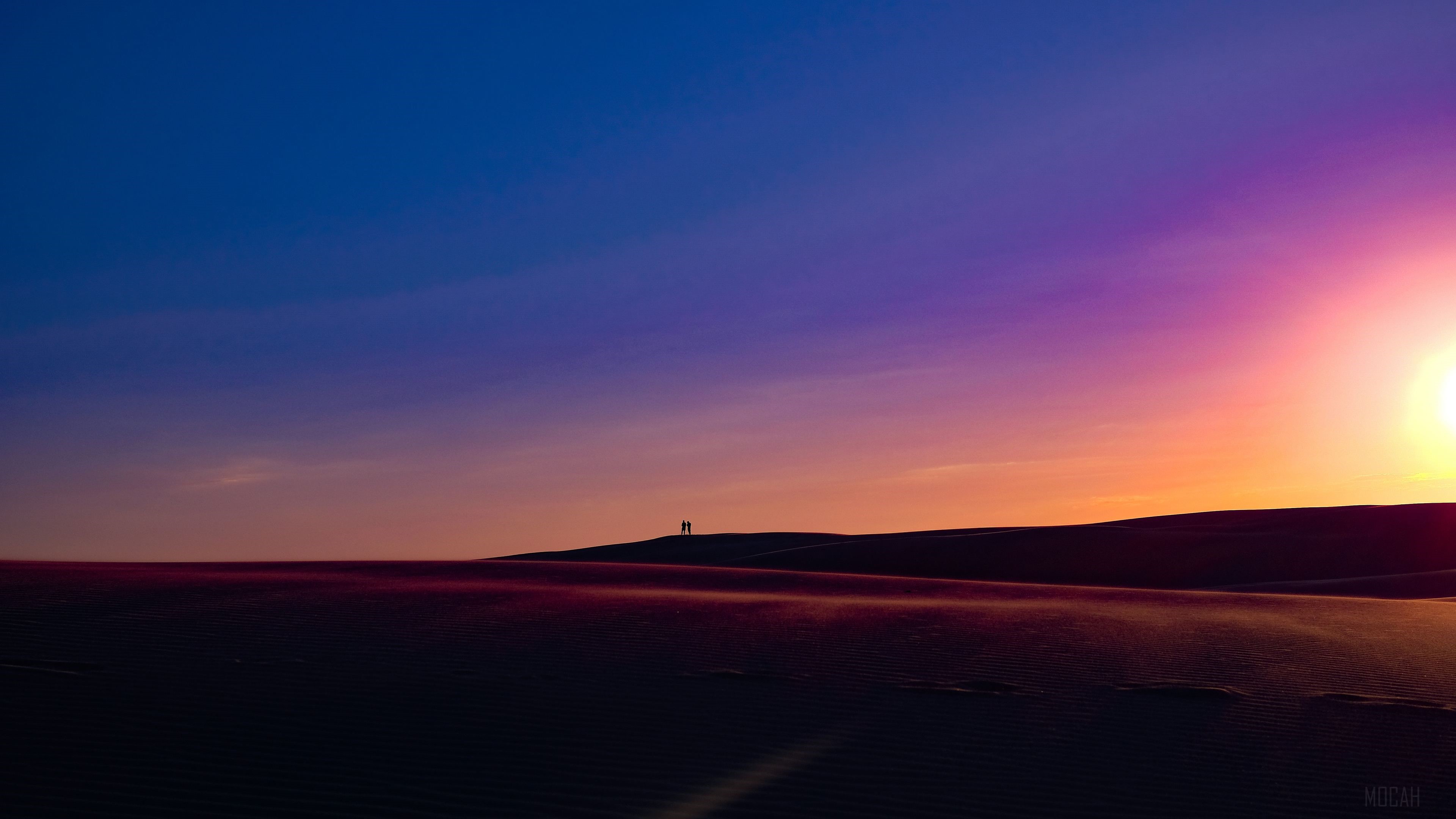 Two people on a sand dune at sunset 4K HD Wallpaper