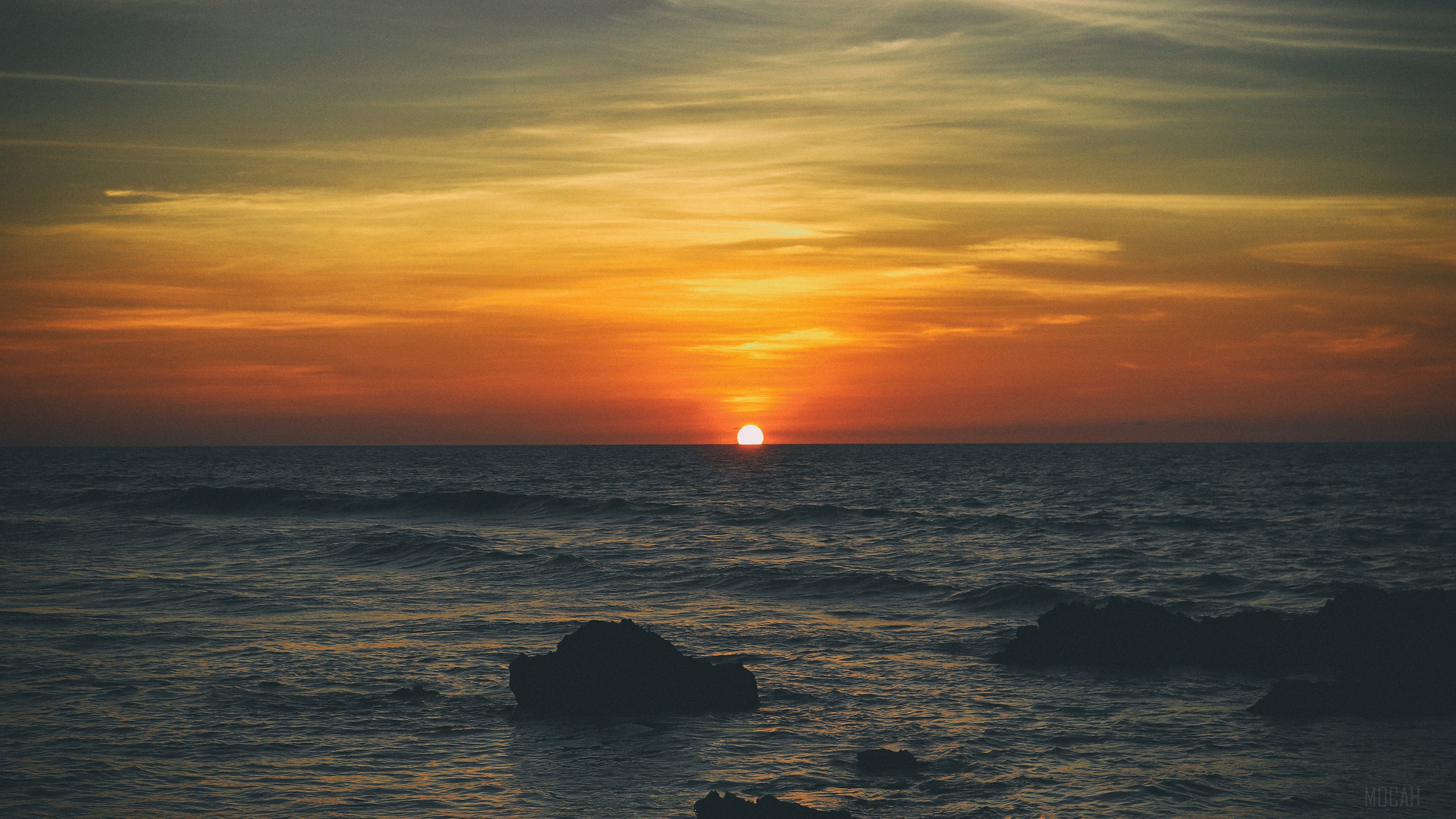 Sunset over the ocean with rocks HD Wallpaper