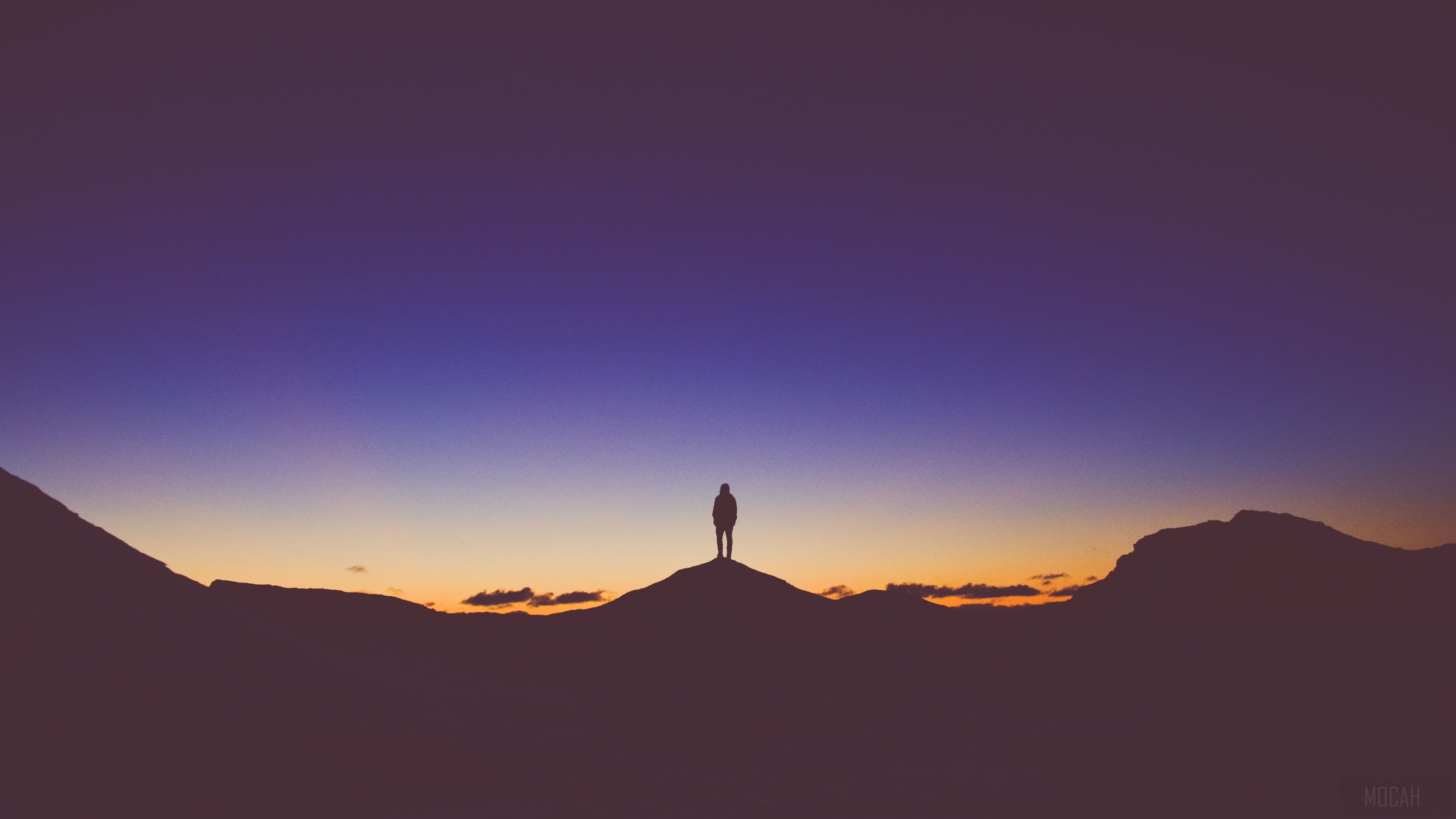 Silhouette of a person standing on a mountain at sunset HD Wallpaper