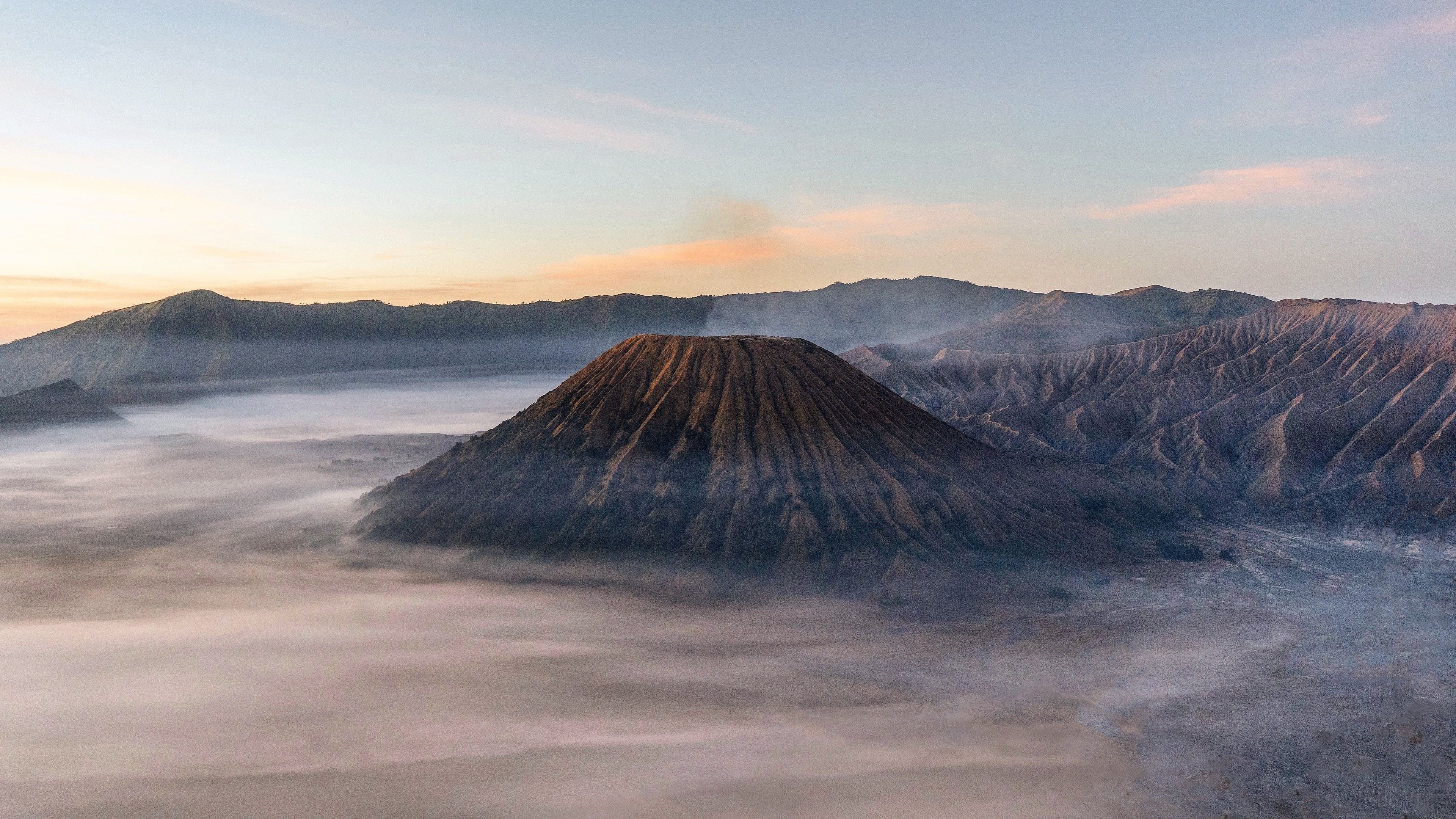 Mount Bromo volcano shrouded in mist at sunrise HD Wallpaper