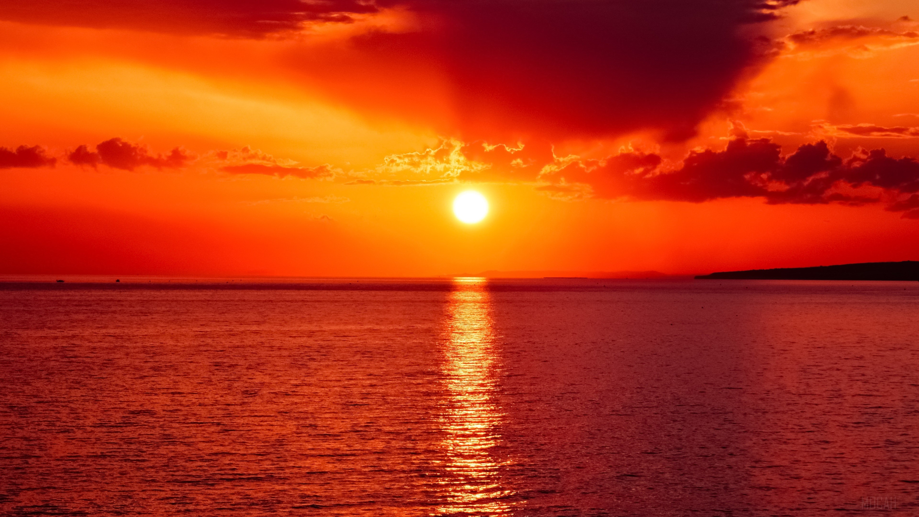 Sunset over the ocean with dark clouds HD Wallpaper