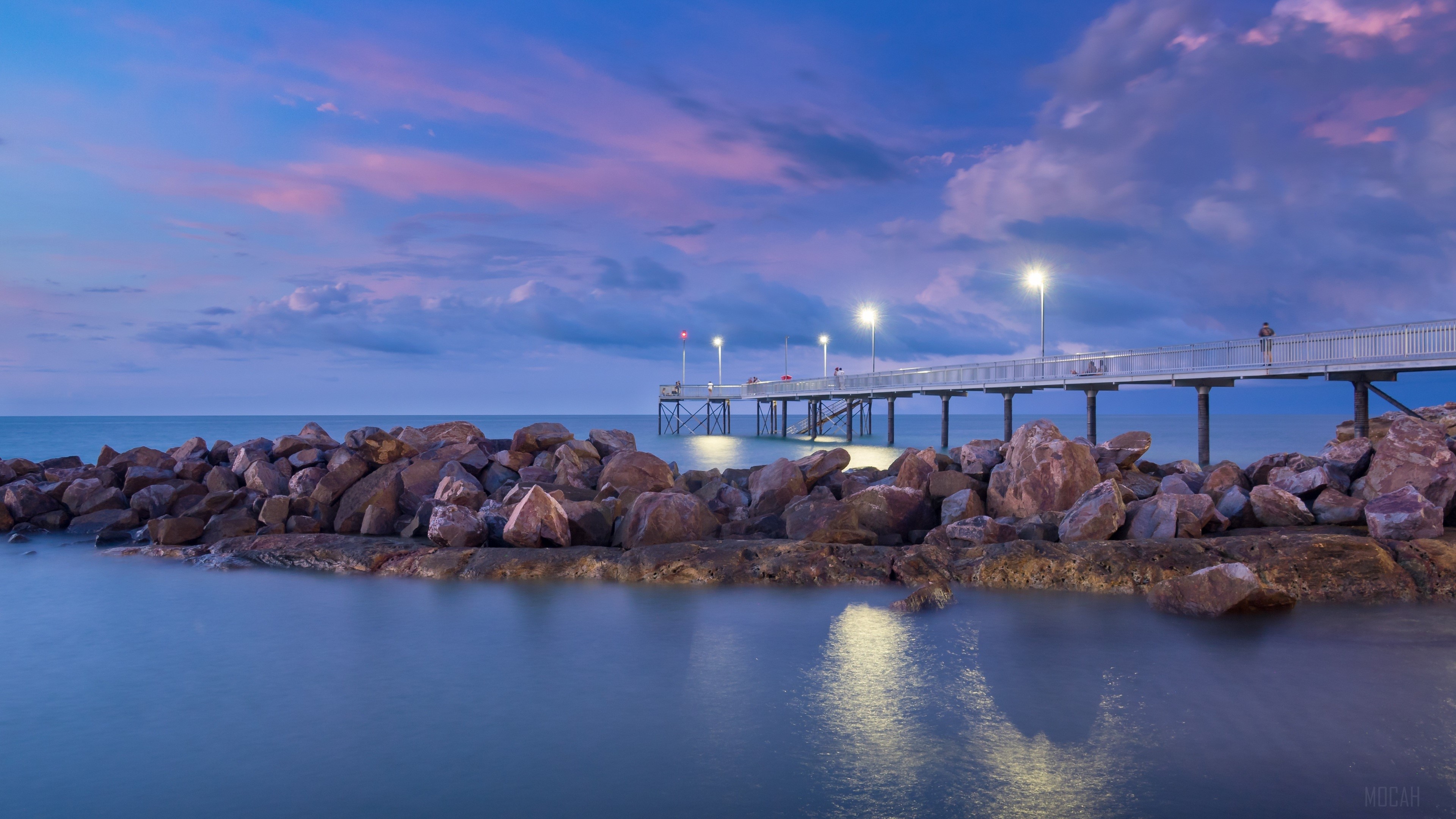 Sunset pier with rocks and ocean 4K HD Wallpaper