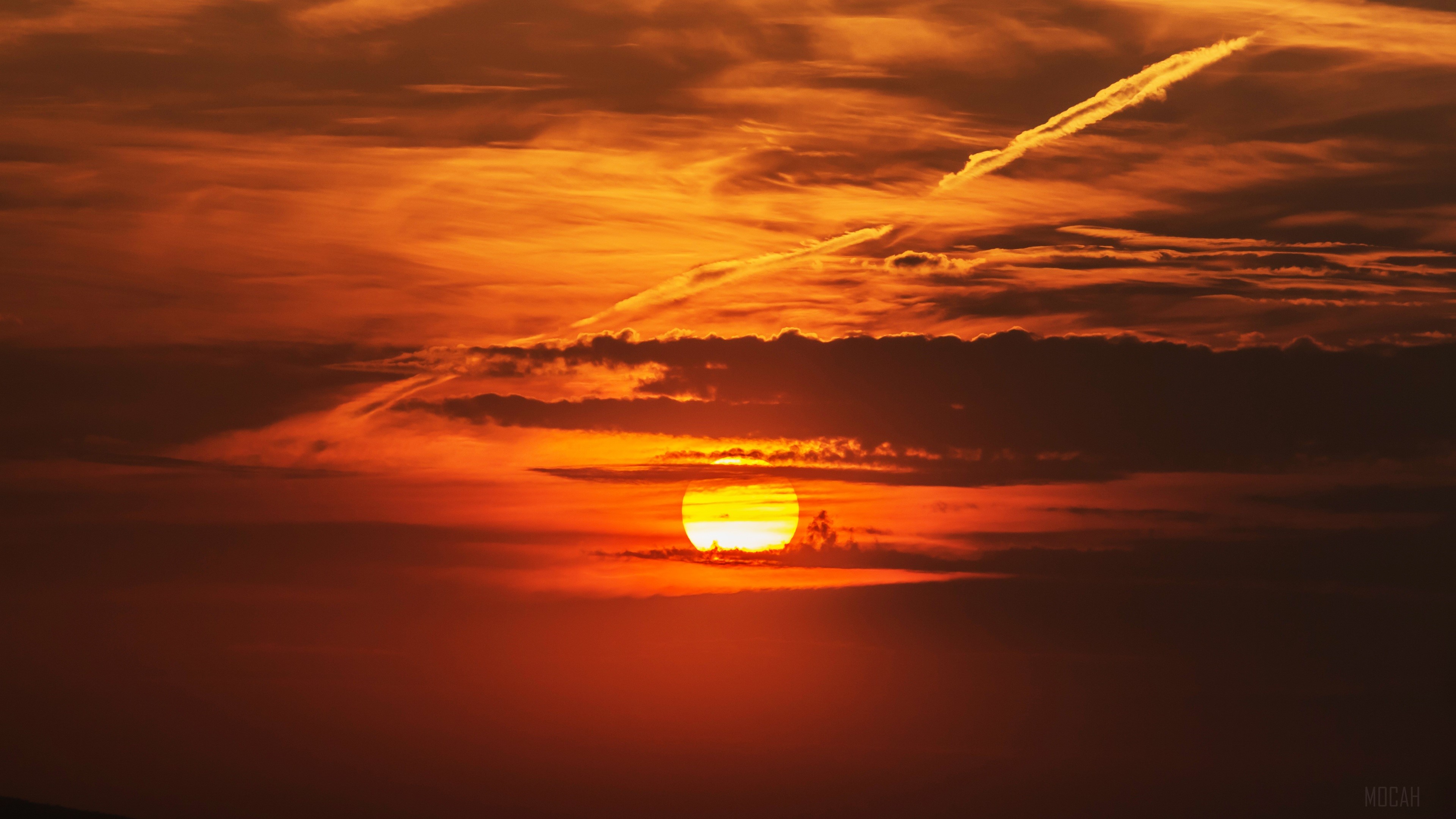 Sunset behind clouds with contrail HD Wallpaper
