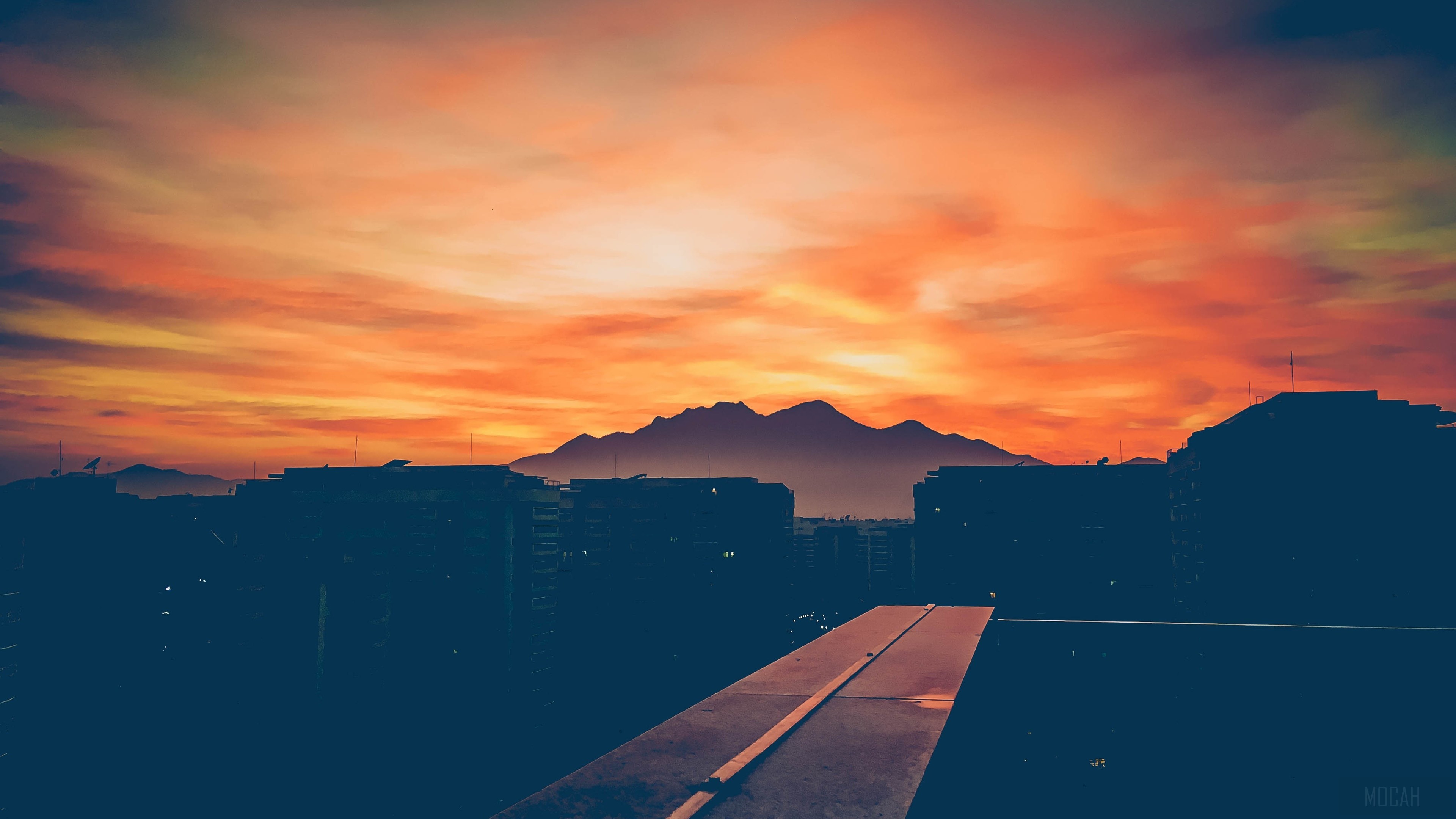 Sunset over city buildings and mountains HD Wallpaper