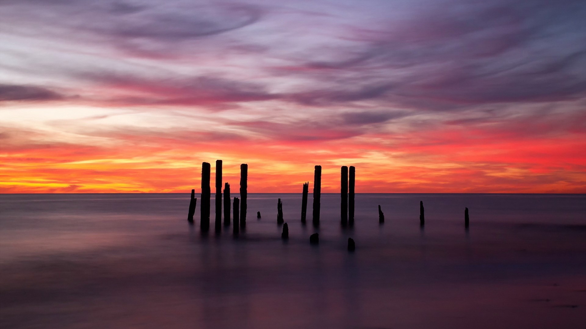 Pilings in the ocean at sunset HD Wallpaper