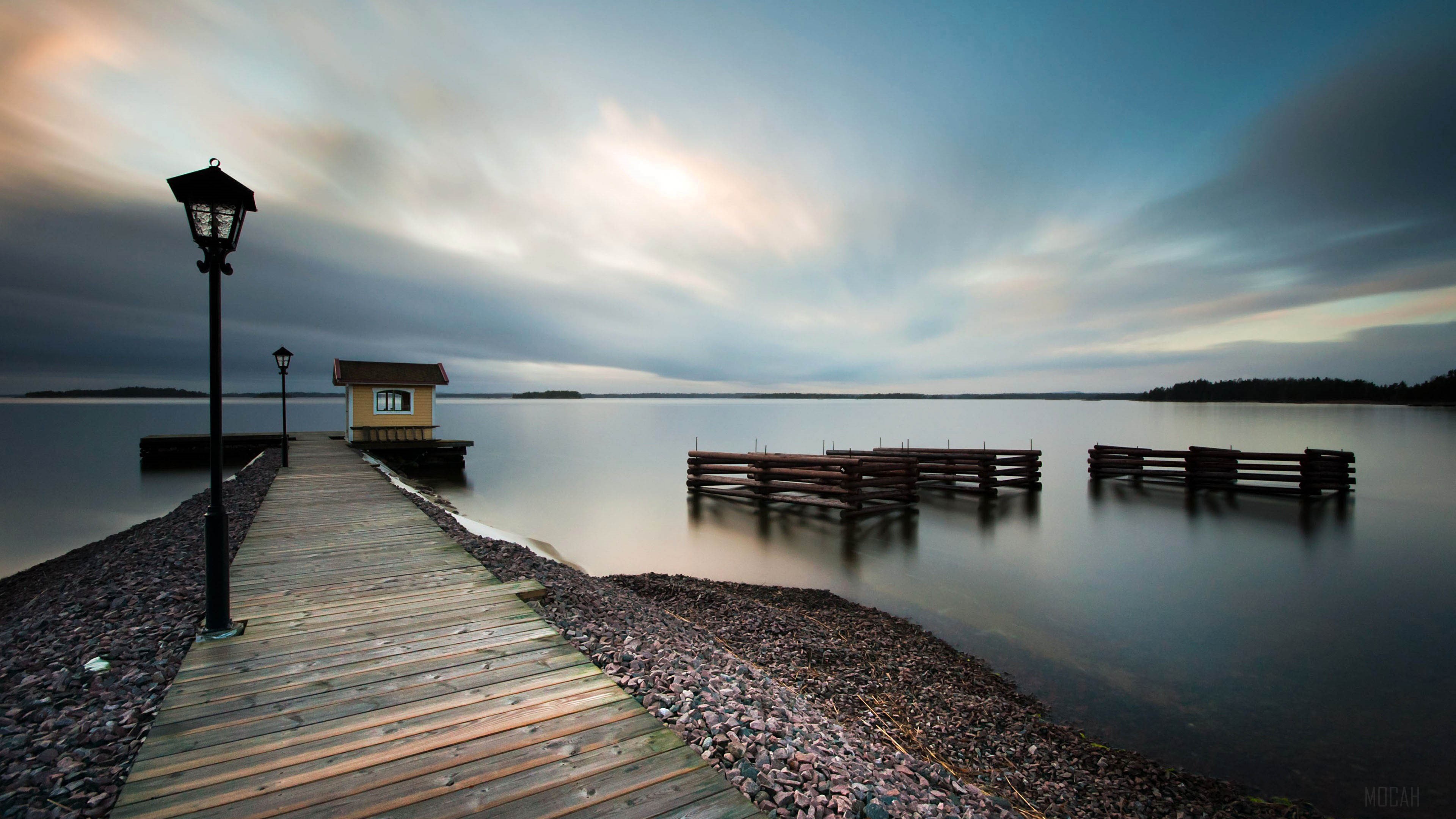 Wooden pier with a small house and lampposts on a lake HD Wallpaper