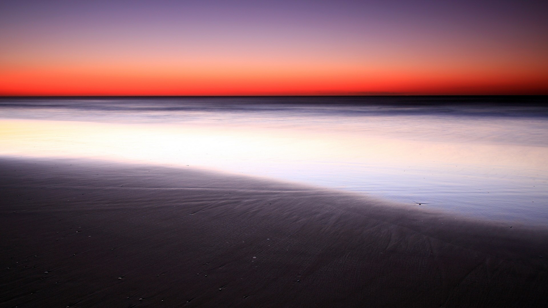 Beach at sunset with calm ocean waves HD Wallpaper