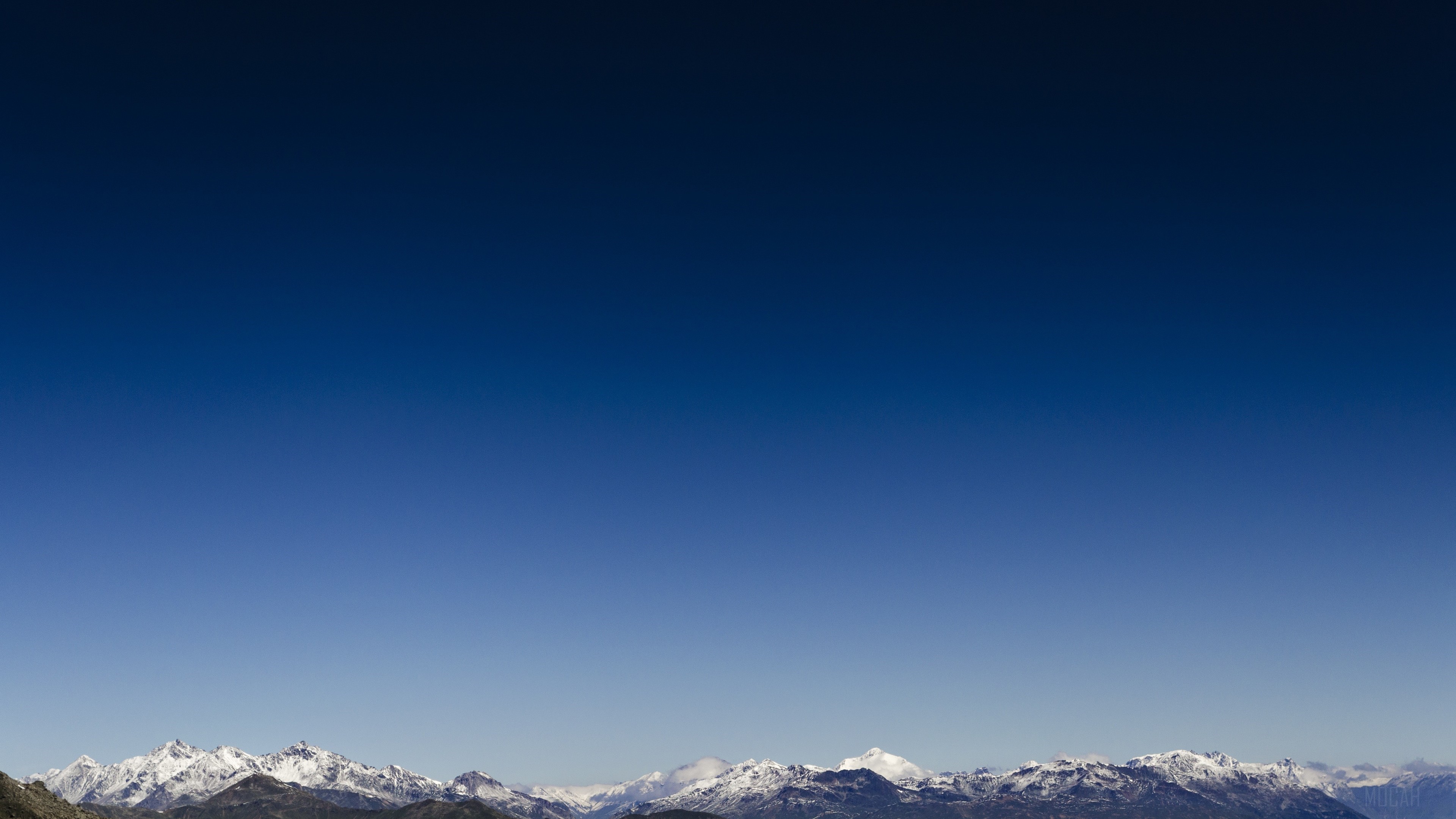 Snow-capped mountains under a clear blue sky HD Wallpaper