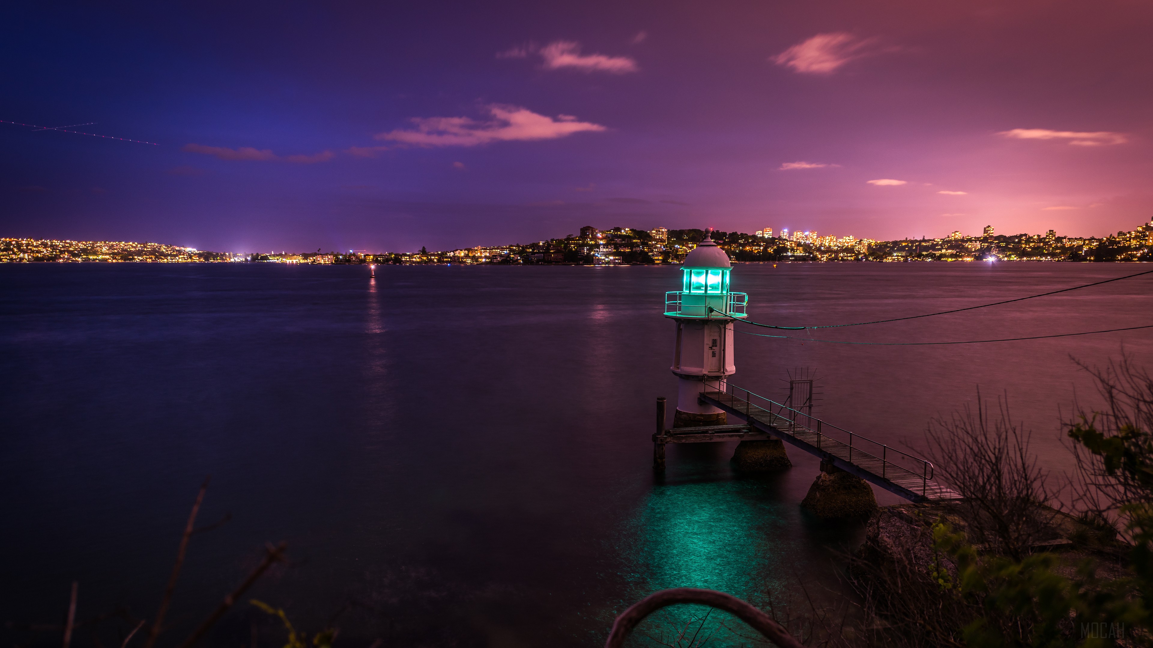 Lighthouse at dusk with city lights HD Wallpaper