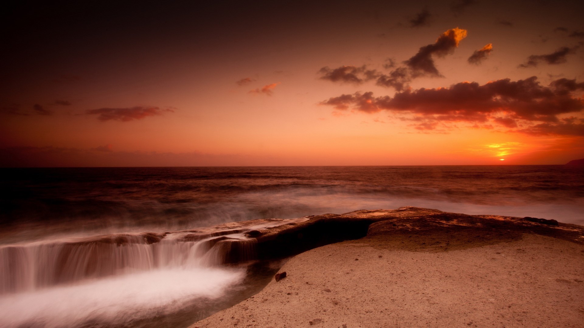 Sunset over the ocean with rocky shore HD Wallpaper