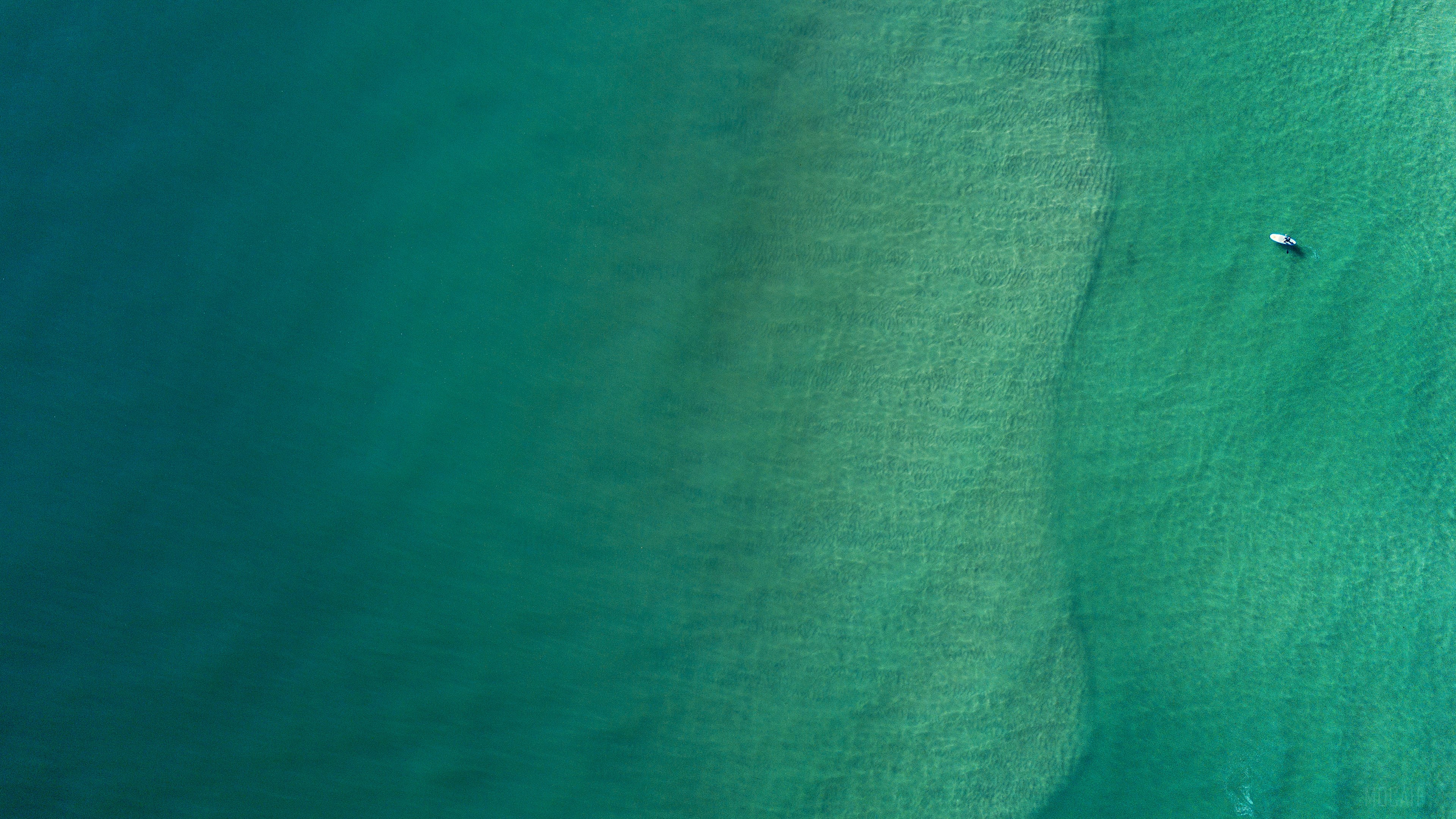 Aerial view of a person on a paddleboard in the sea HD Wallpaper