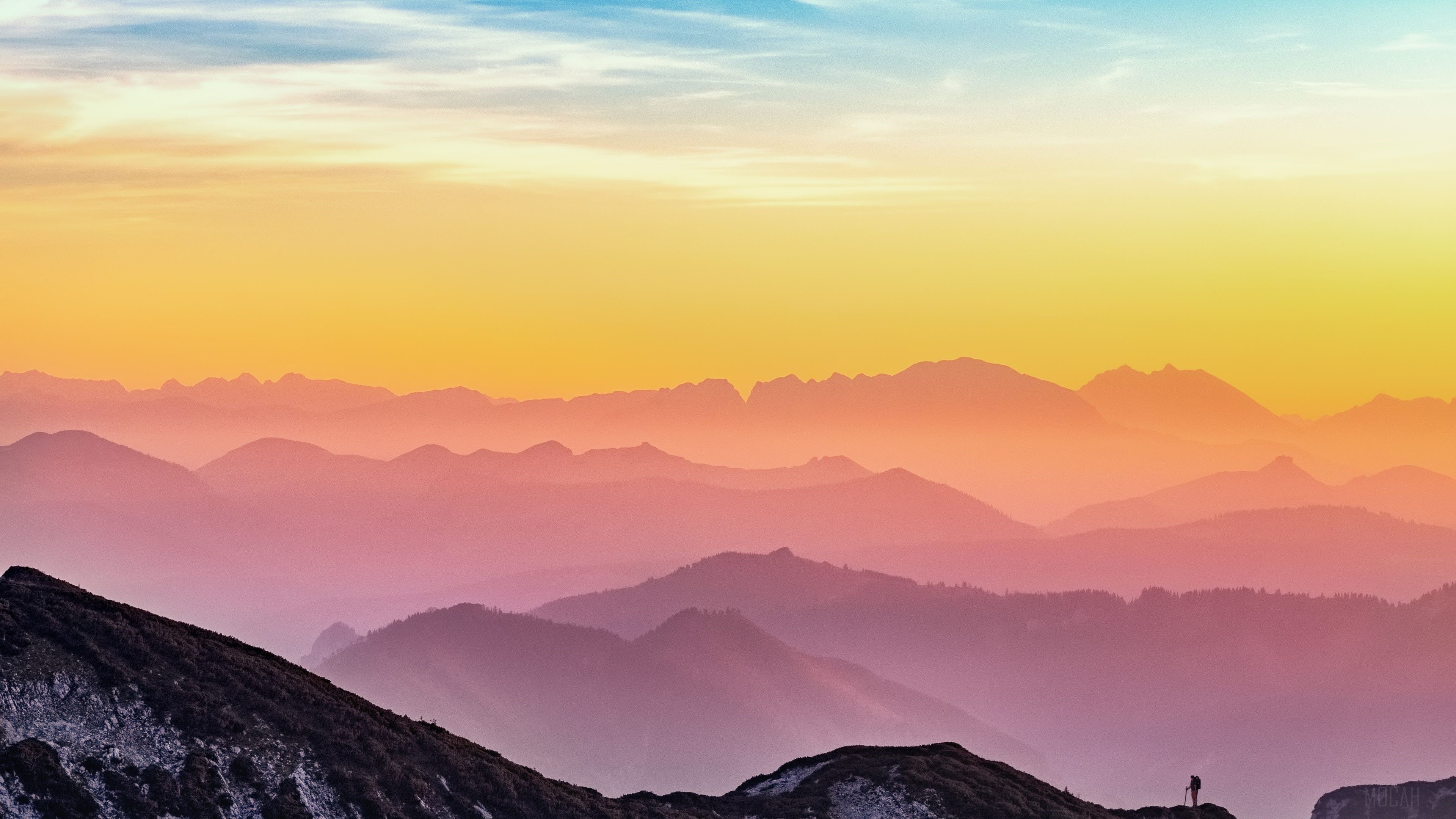 Mountains at sunset with a lone hiker HD Wallpaper