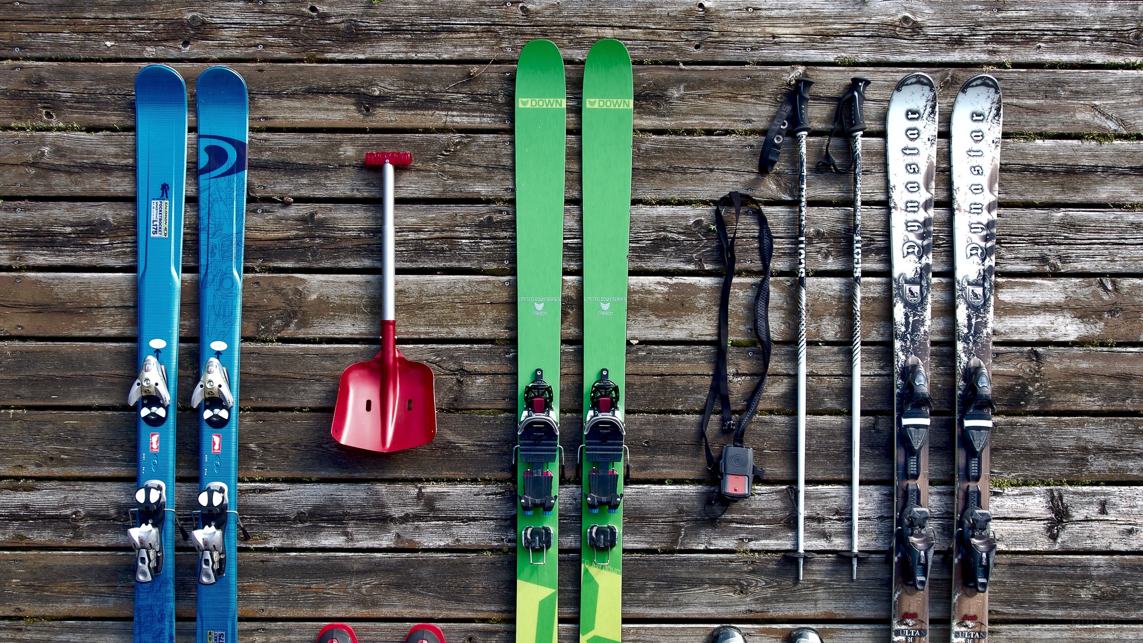 Skis, poles, and shovel on wooden background HD Wallpaper