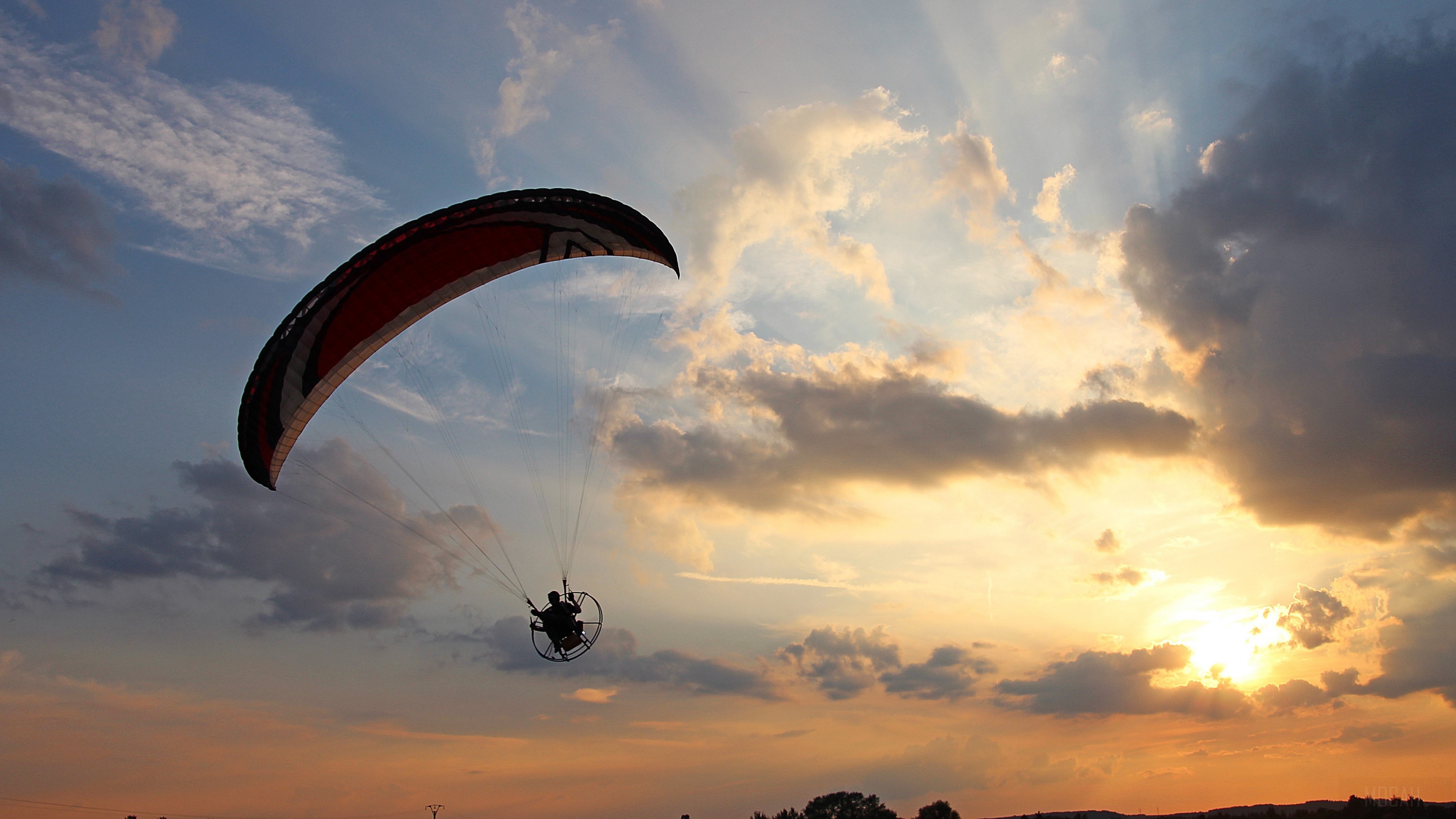 Paramotorist flying at sunset HD Wallpaper