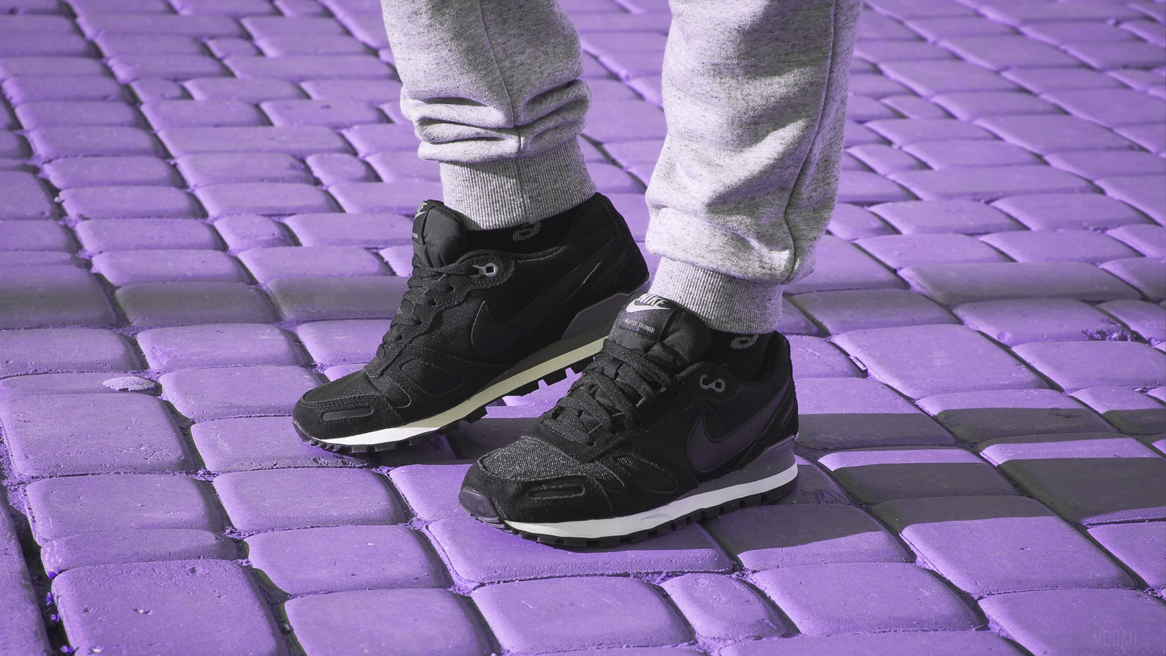 Nike sneakers on a person standing on purple pavement HD Wallpaper