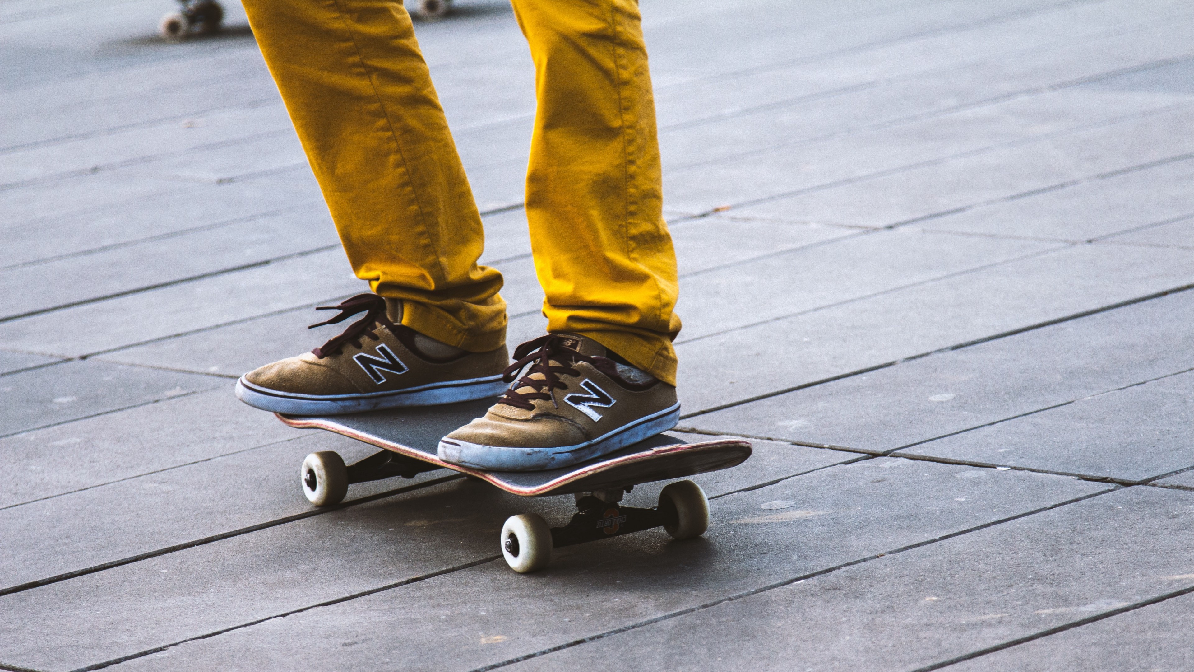 Person on skateboard wearing yellow pants and sneakers 4K HD Wallpaper