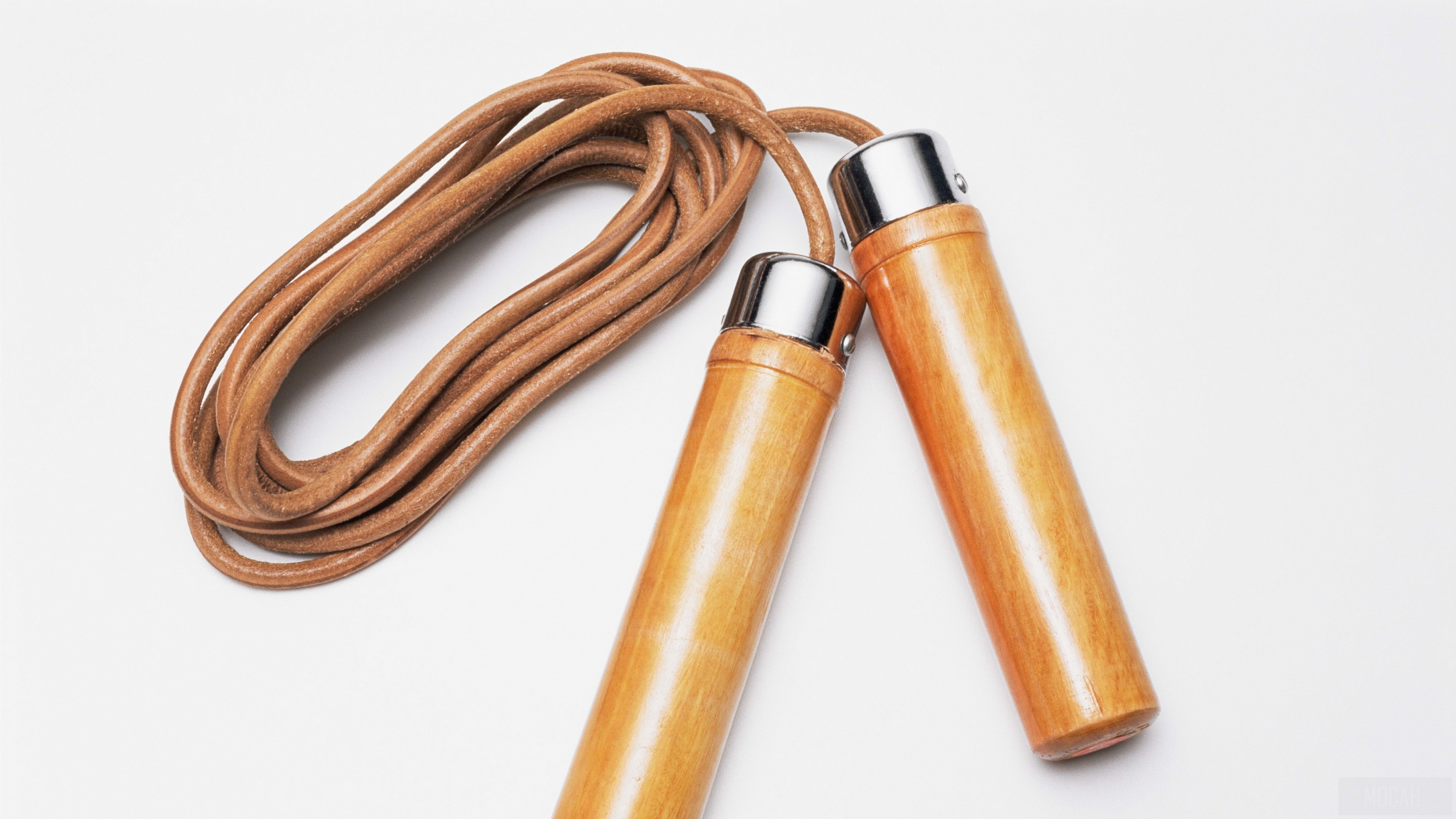 Leather jump rope with wooden handles on white background HD Wallpaper