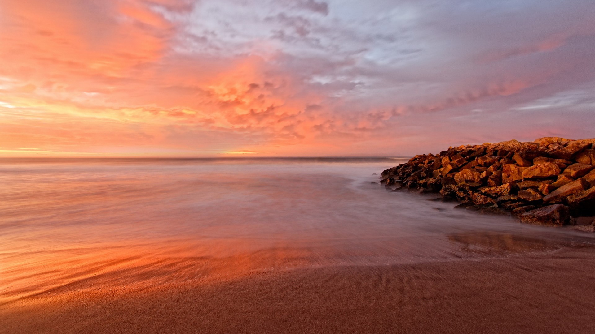 Sunset over the ocean with a rocky shore HD Wallpaper
