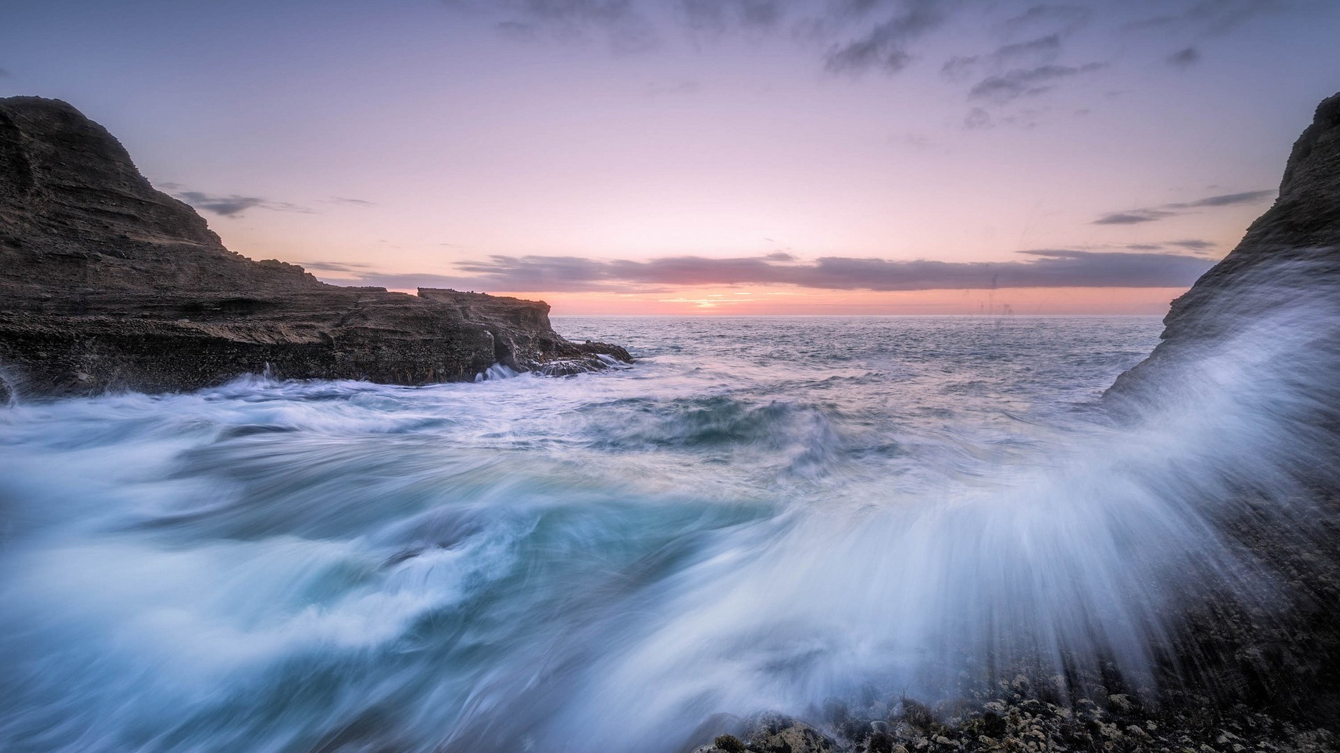 Waves crashing against rocky shore at sunset HD Wallpaper