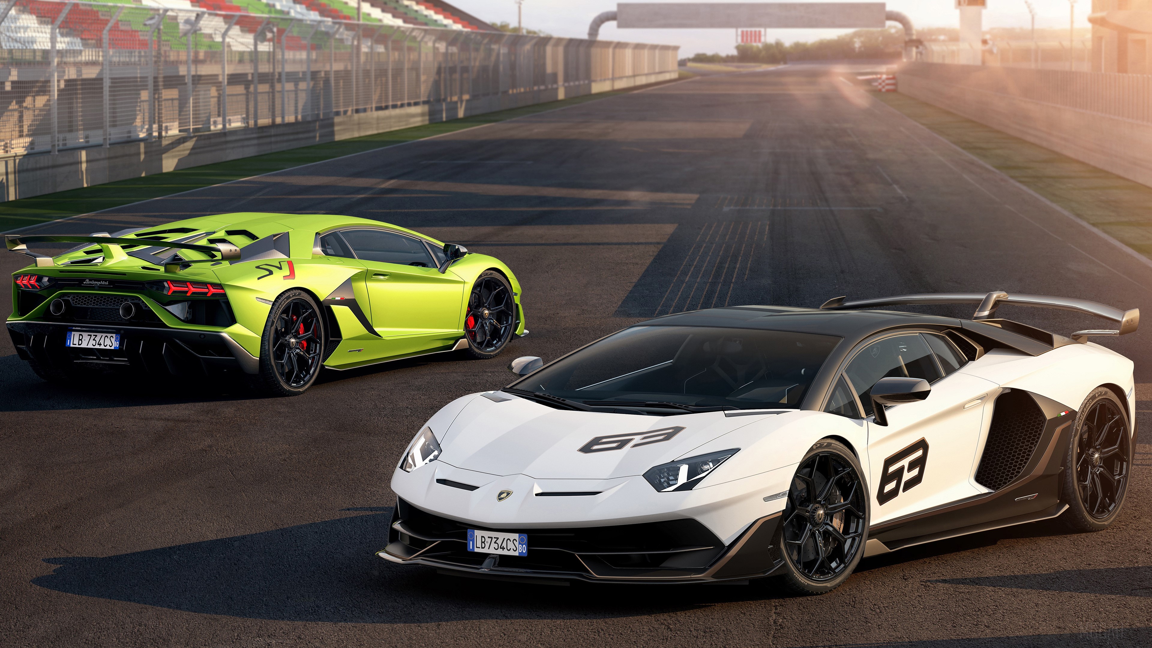 Two Lamborghini Aventador SVJ cars on a racetrack HD Wallpaper
