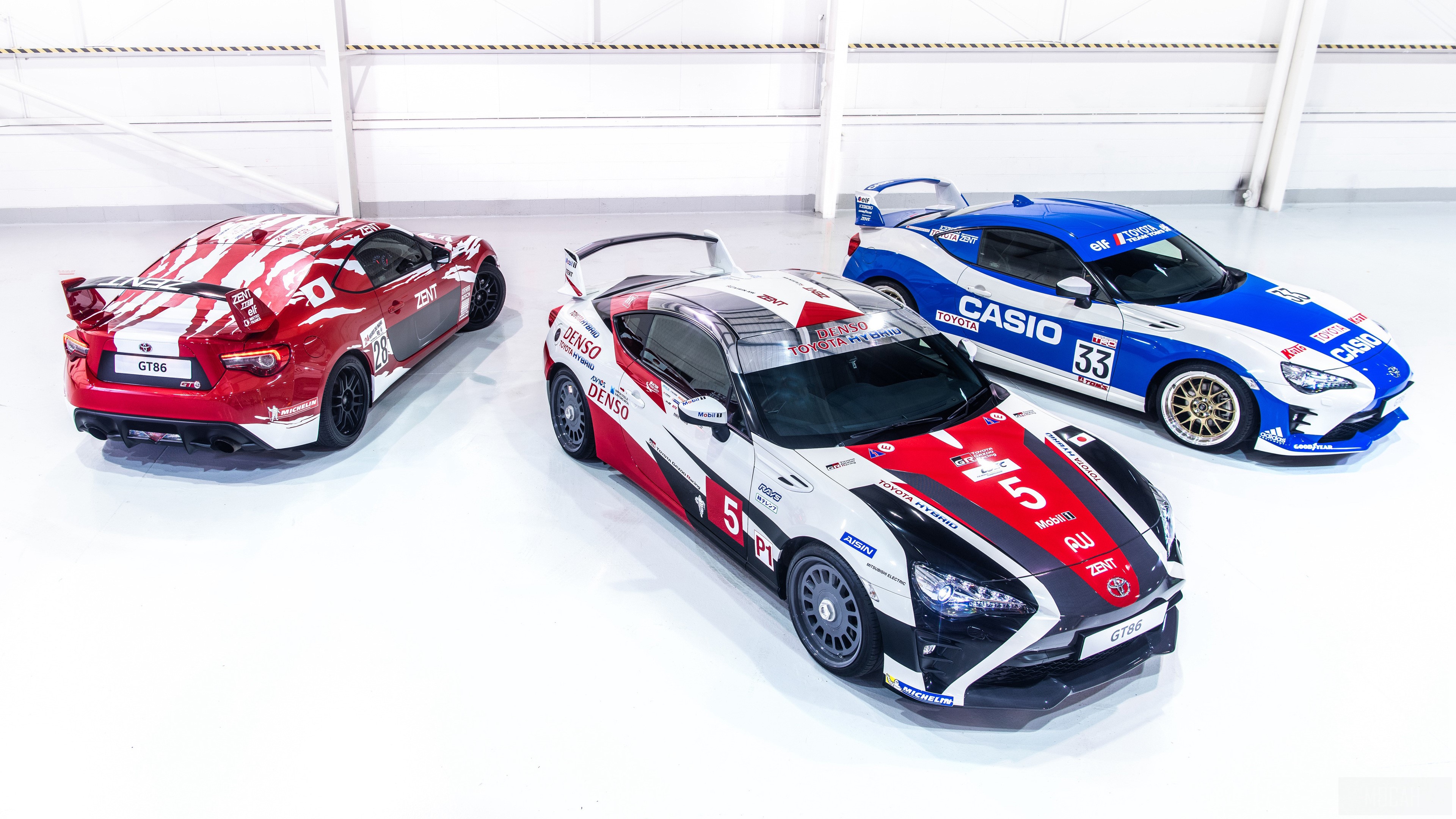 Three Toyota GT86 race cars in a warehouse HD Wallpaper