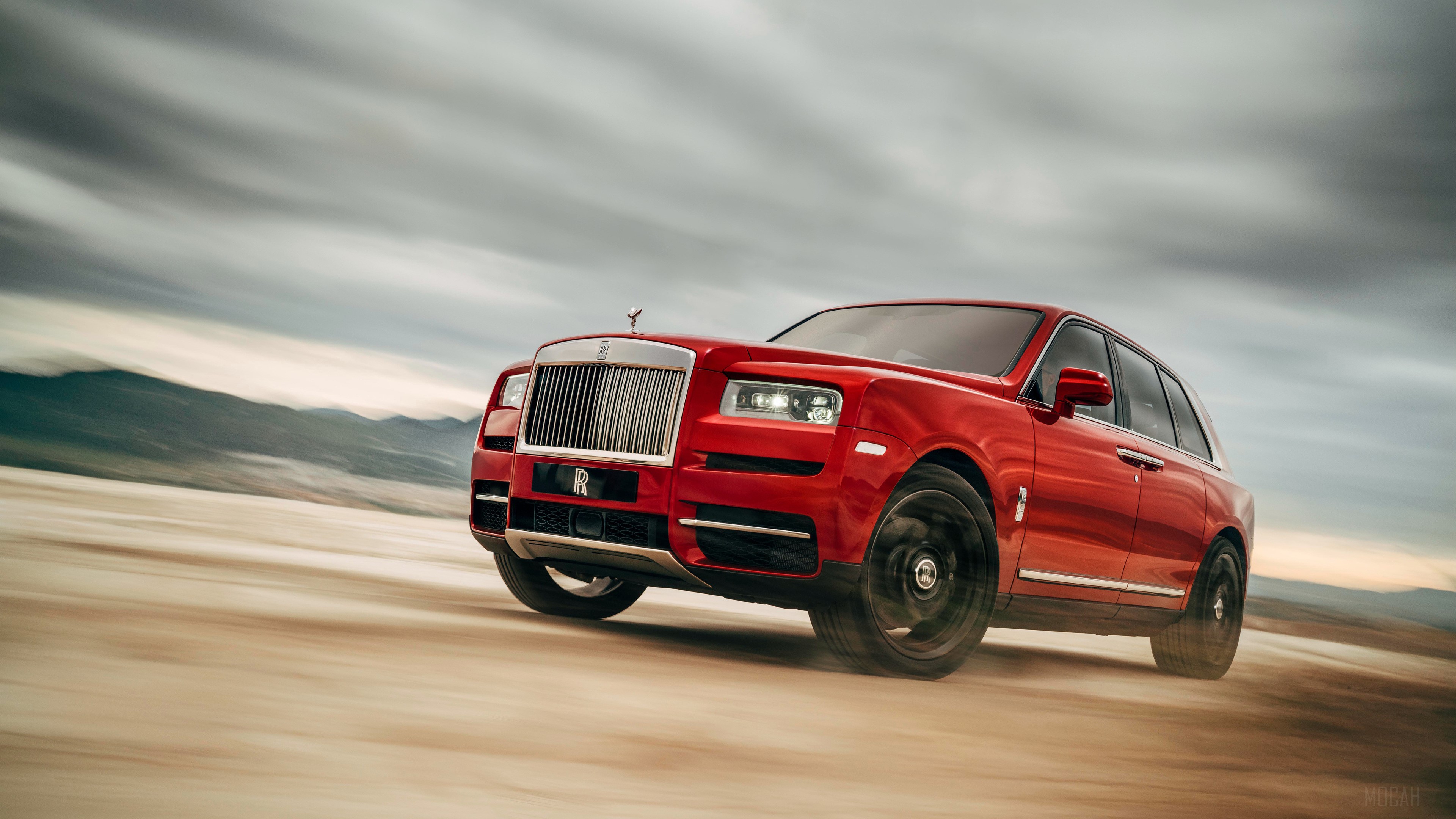 Red Rolls Royce Cullinan SUV driving on dirt road HD Wallpaper