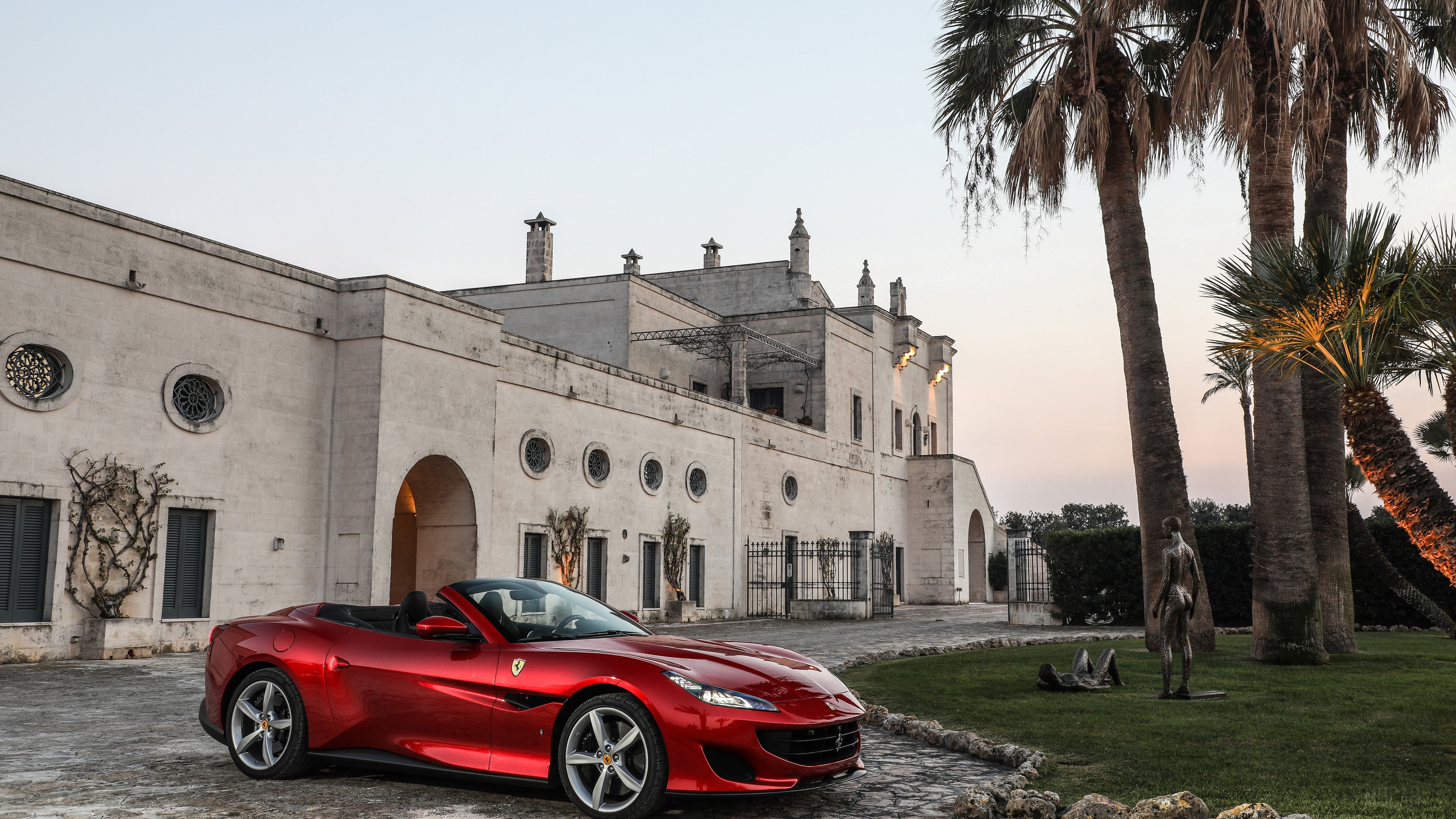 Red Ferrari Portofino convertible parked in front of a villa HD Wallpaper