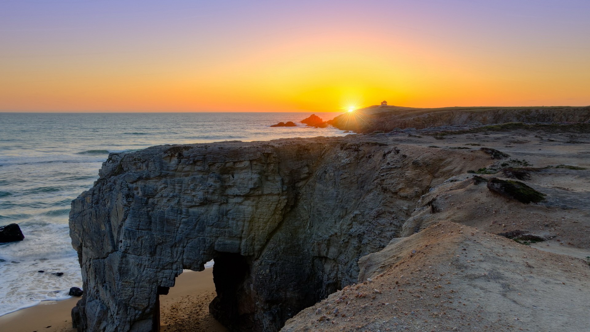 Arch rock formation at sunset over the ocean HD Wallpaper
