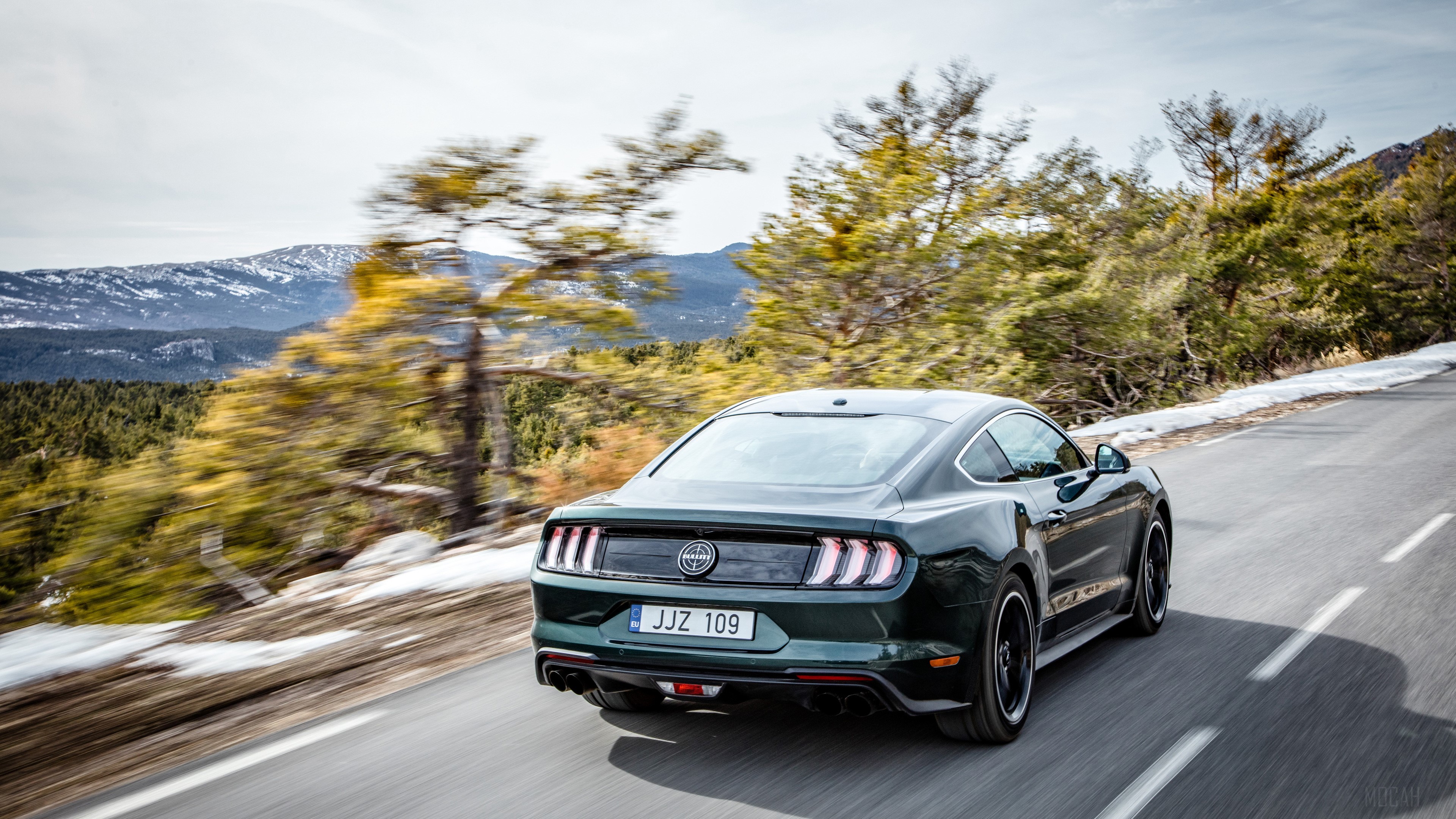 2018 Ford Mustang Bullitt driving on a mountain road HD Wallpaper