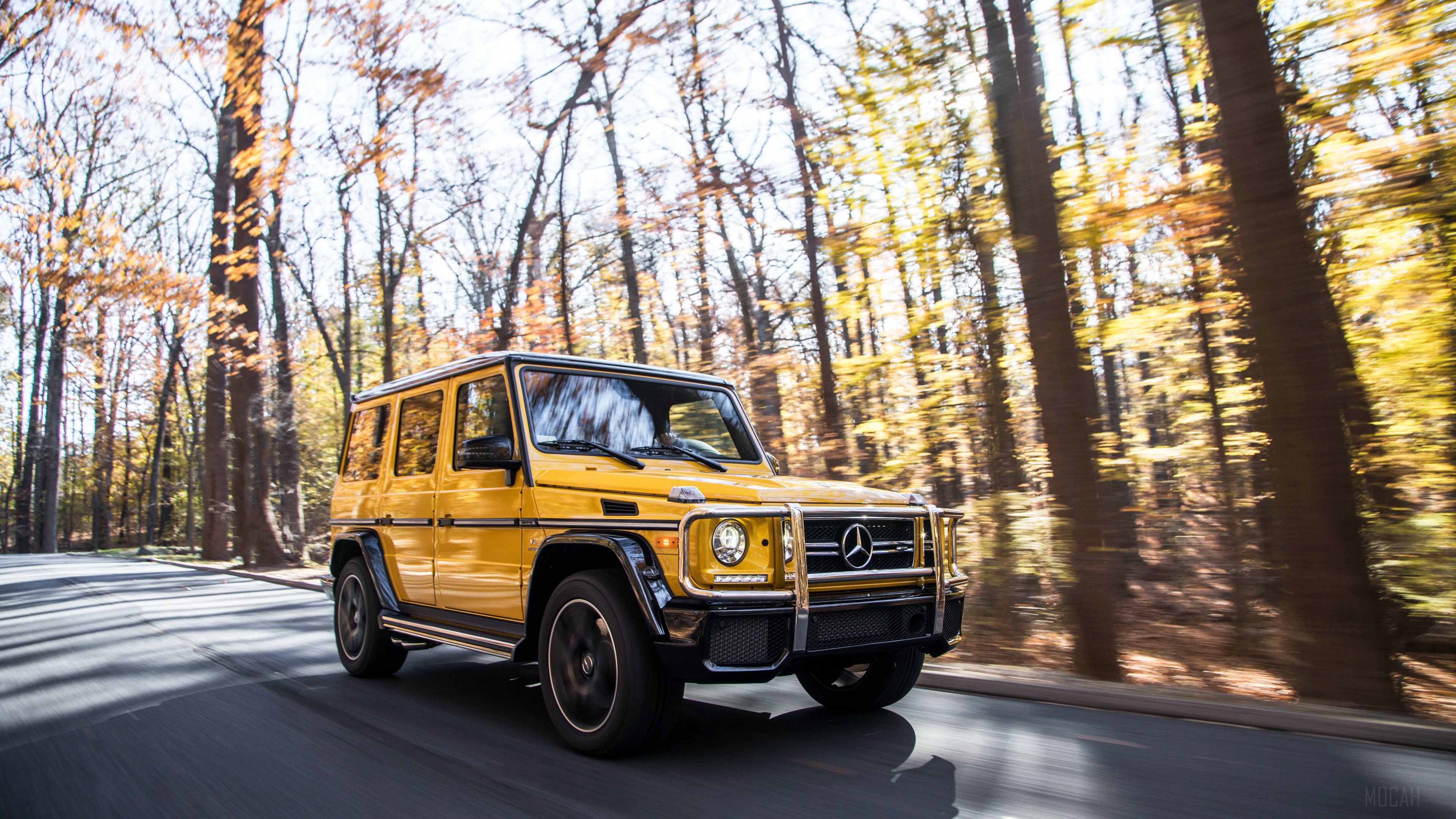 Yellow 2017 Mercedes AMG G63 driving on road HD Wallpaper