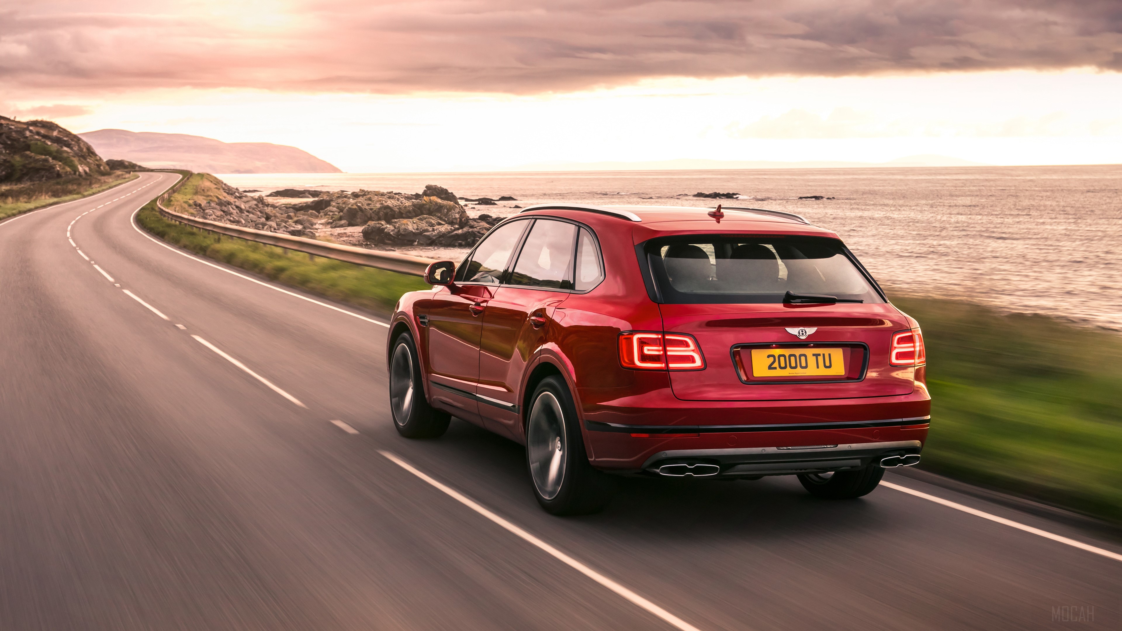 Bentley Bentayga V8 driving on coastal road 4K HD Wallpaper