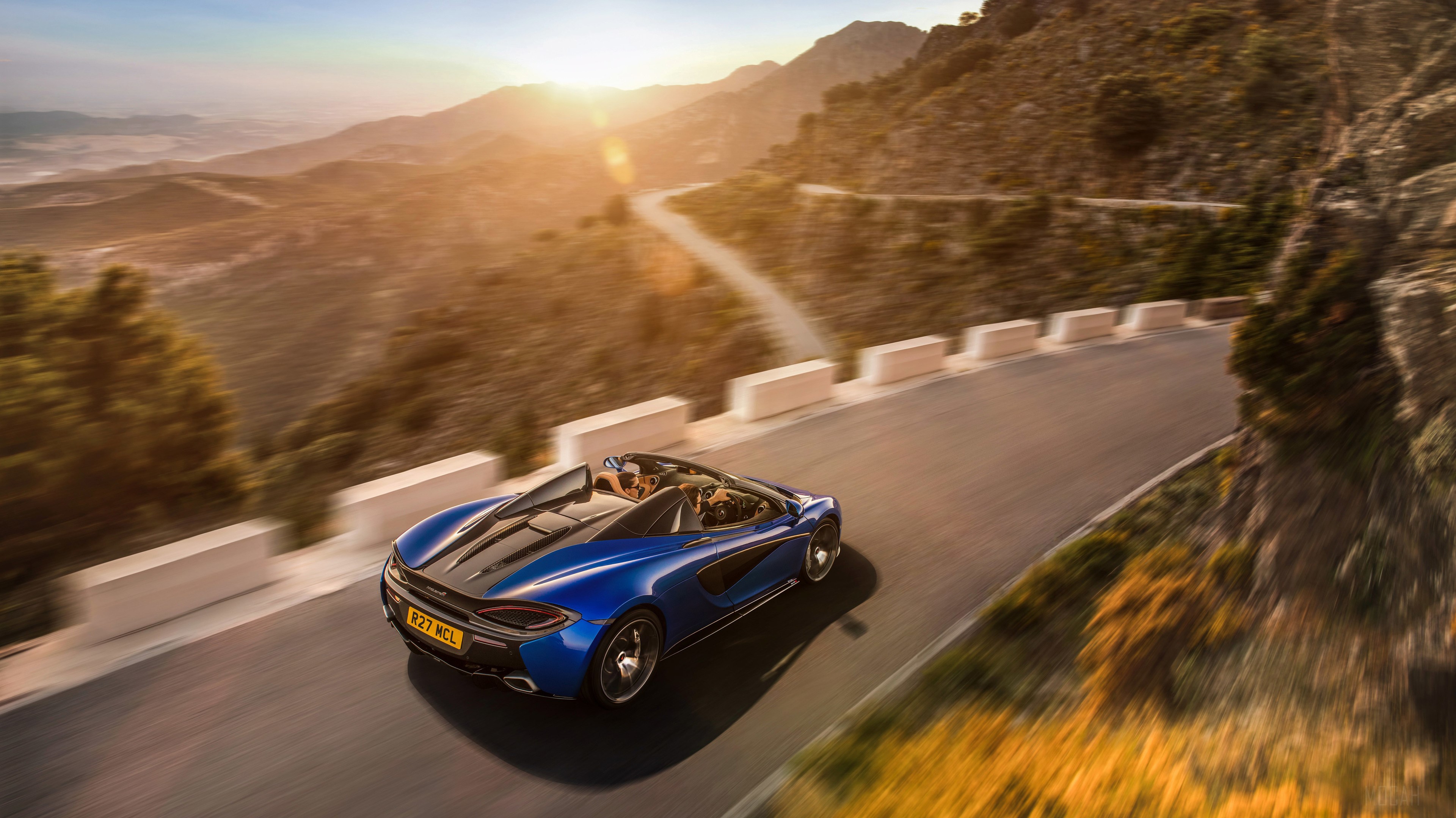Blue McLaren 570S Spider driving on mountain road 4K HD Wallpaper