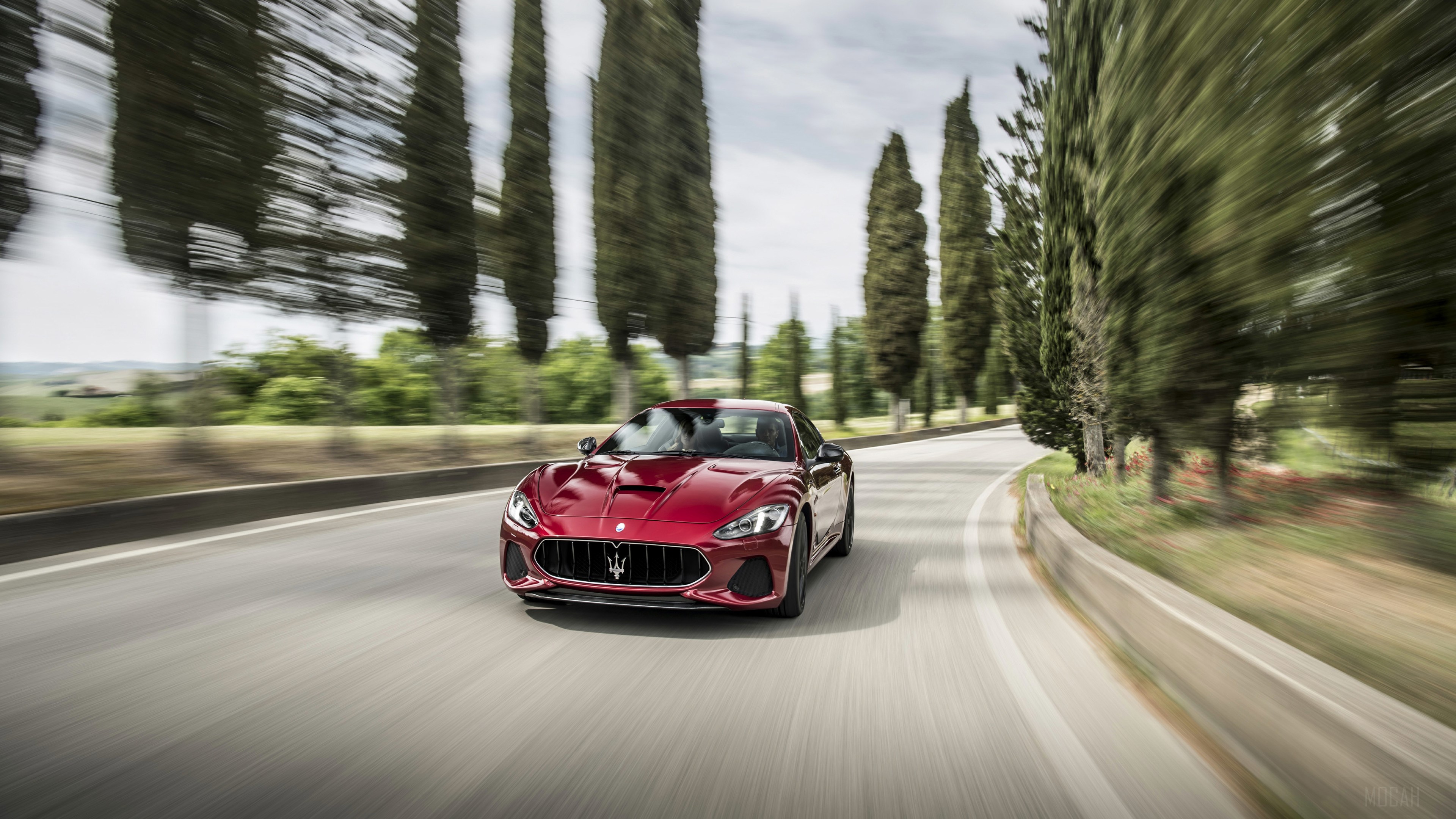 Red Maserati Granturismo driving on a road HD Wallpaper