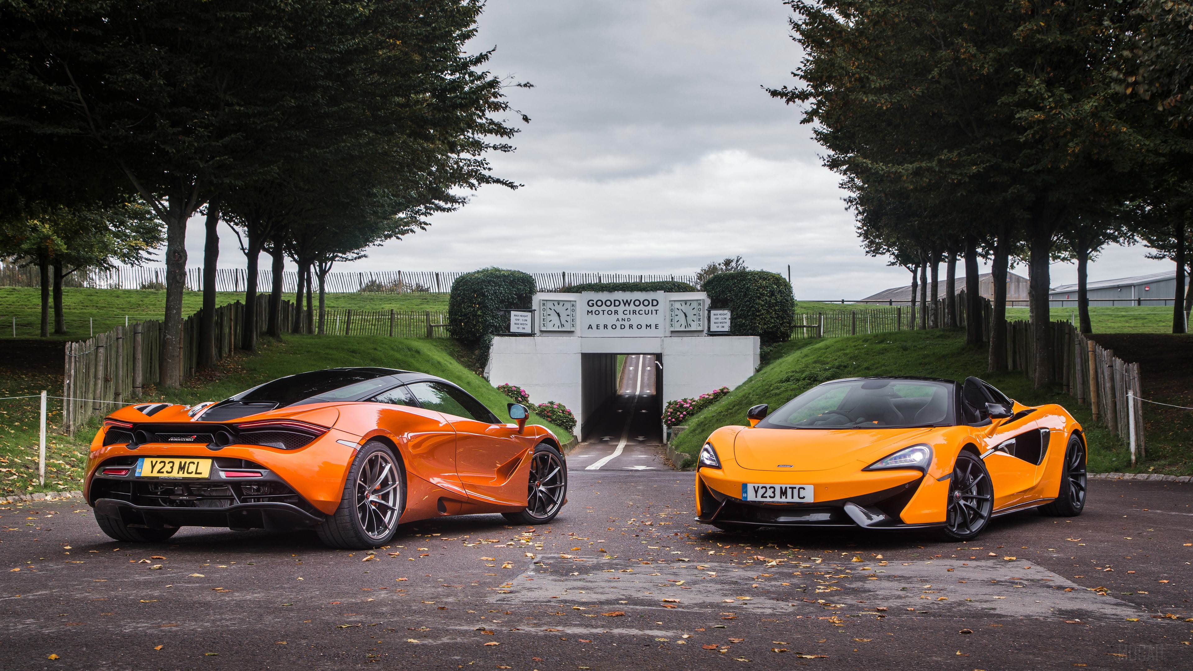 Two McLaren sports cars at Goodwood Motor Circuit HD Wallpaper