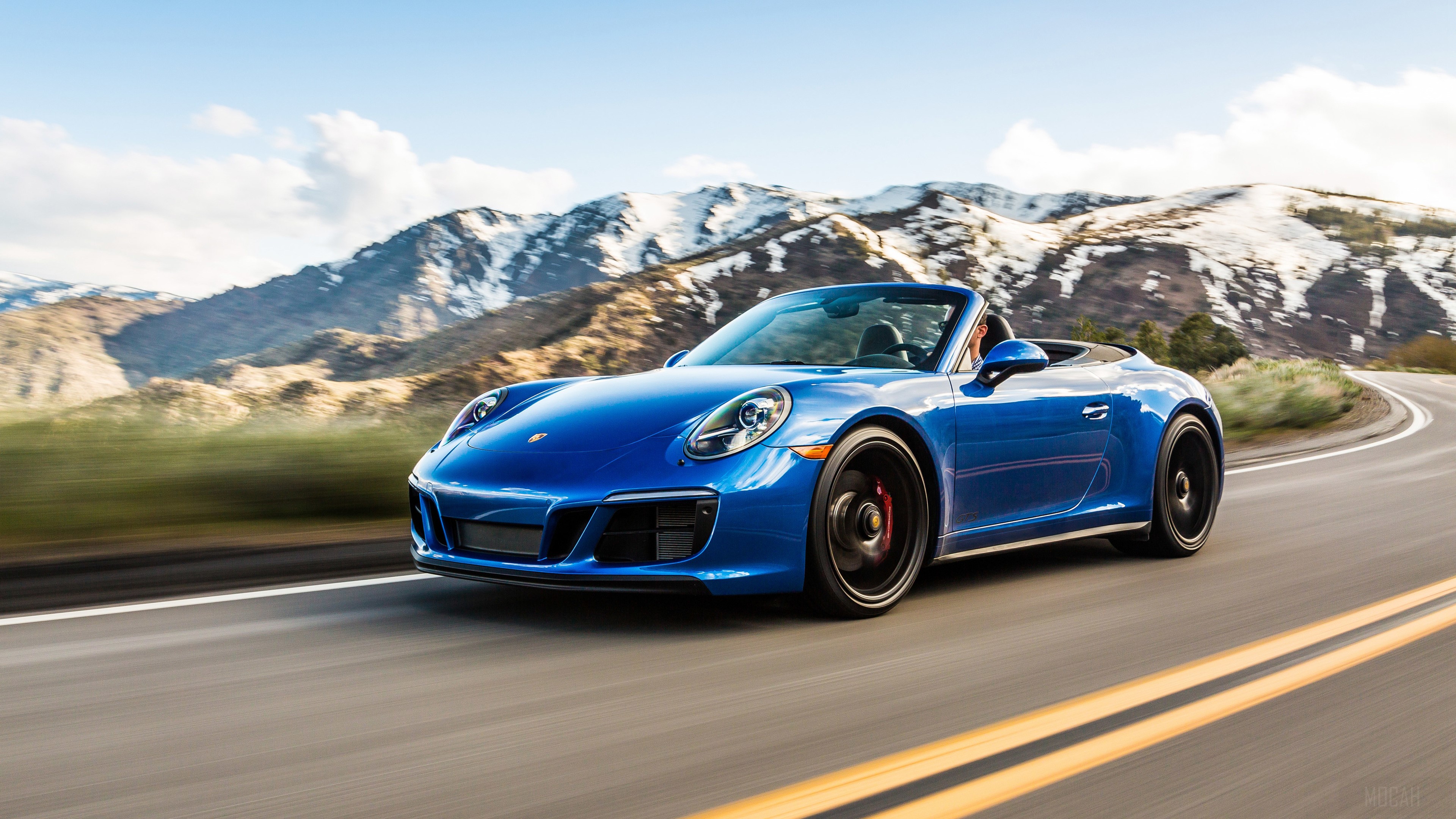 Blue 2018 Porsche 911 Carrera GTS Cabriolet driving on mountain road HD Wallpaper