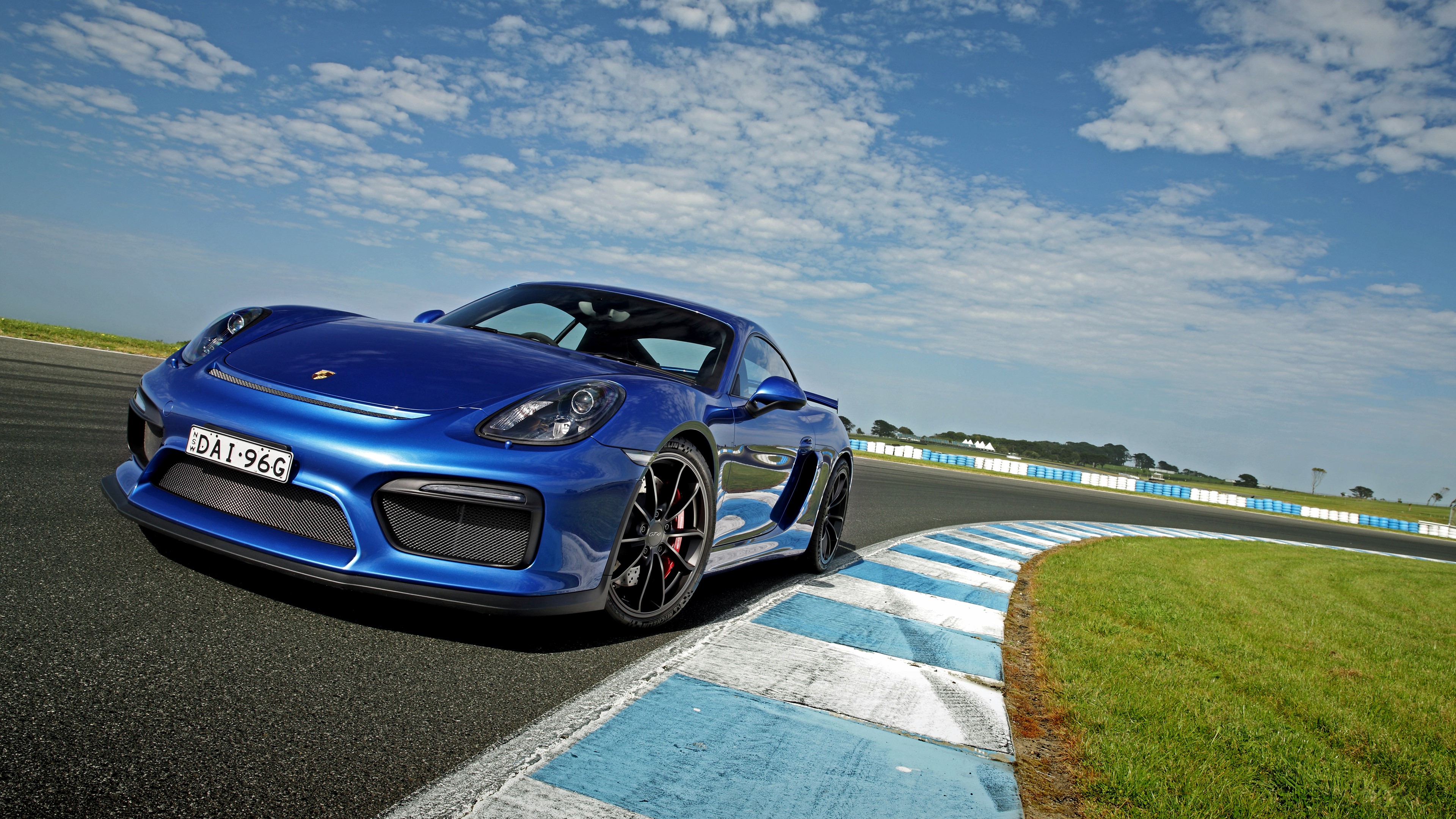 Blue Porsche Cayman GT4 on a Racetrack 4K HD Wallpaper
