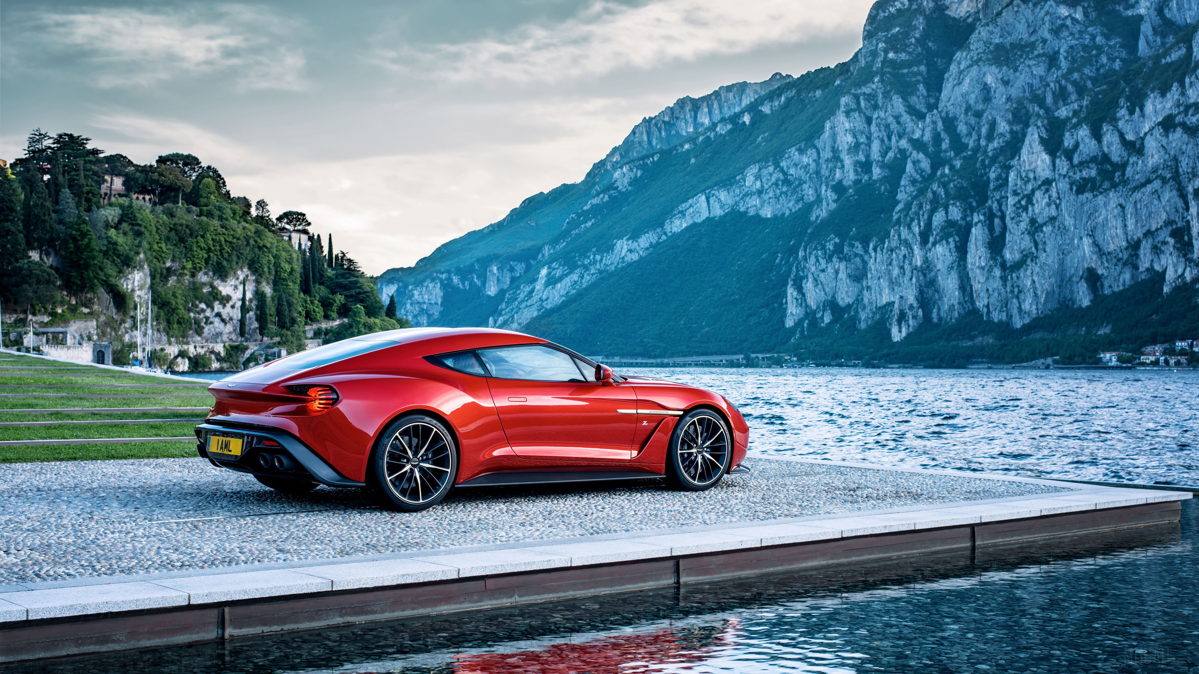 Red Aston Martin Vanquish parked by a lake with mountains HD Wallpaper